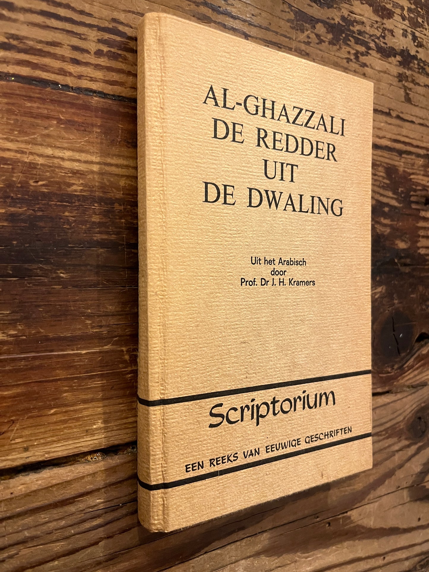 Boek met de titel 'de redder uit de dwaling' door Al-Ghazzali op een houten achtergrond