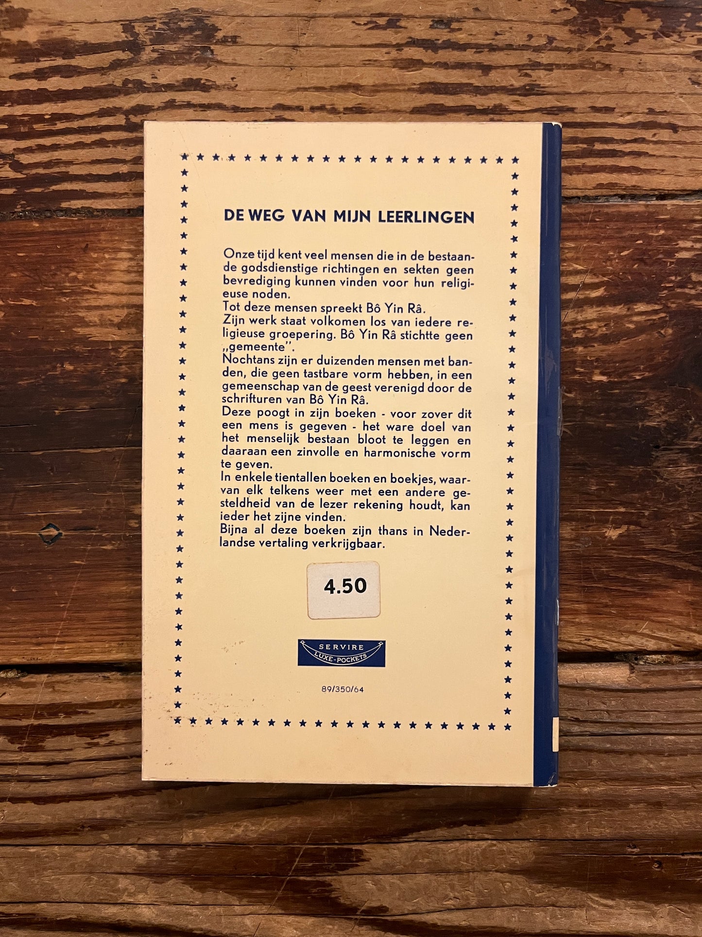 Achterkant van boek met de titel 'De Weg van Leerlingen' door Bo Yin Ra op een houten achtergrond