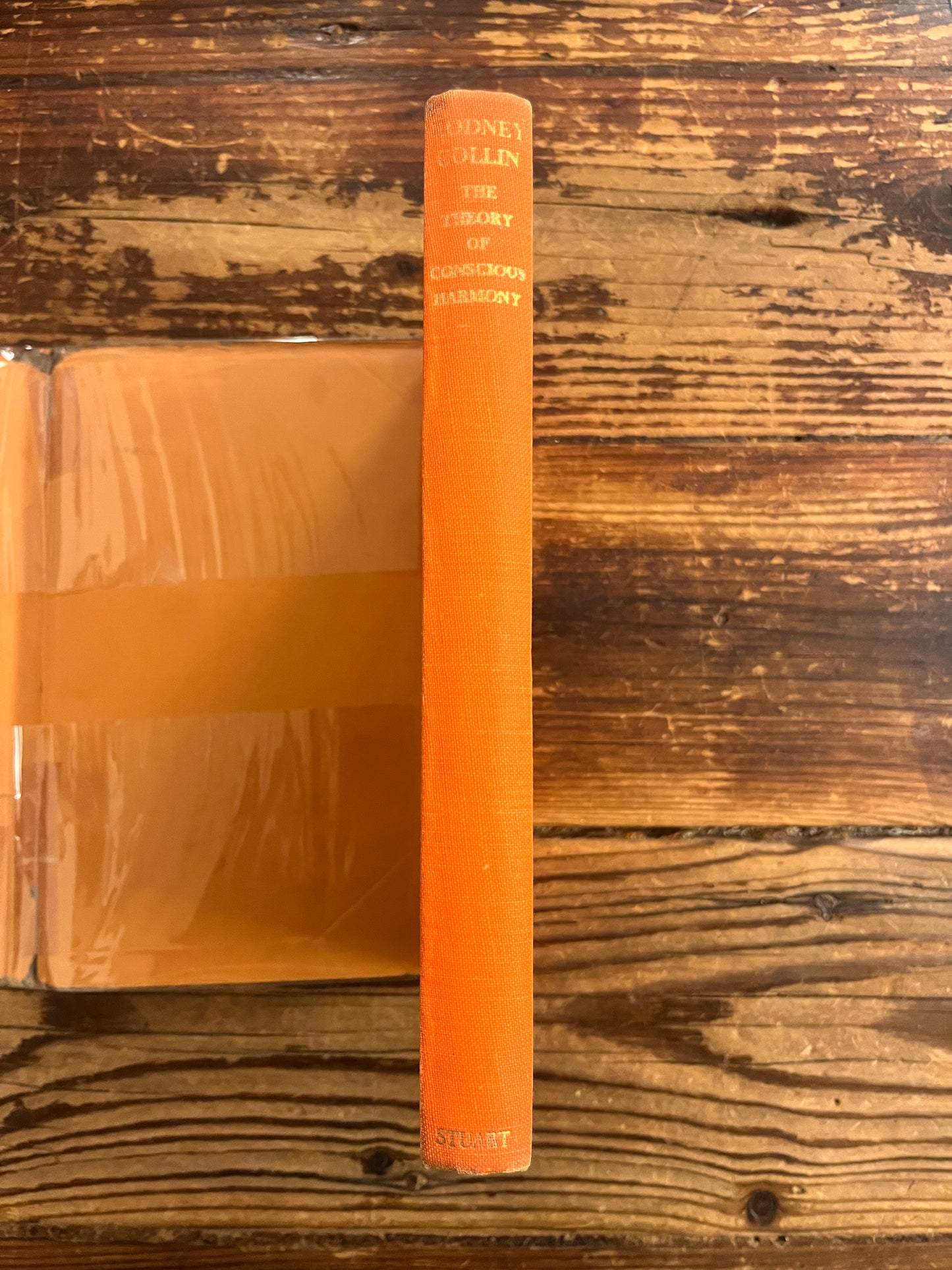 spine of book titled 'theory of conscious harmony' on wooden surface