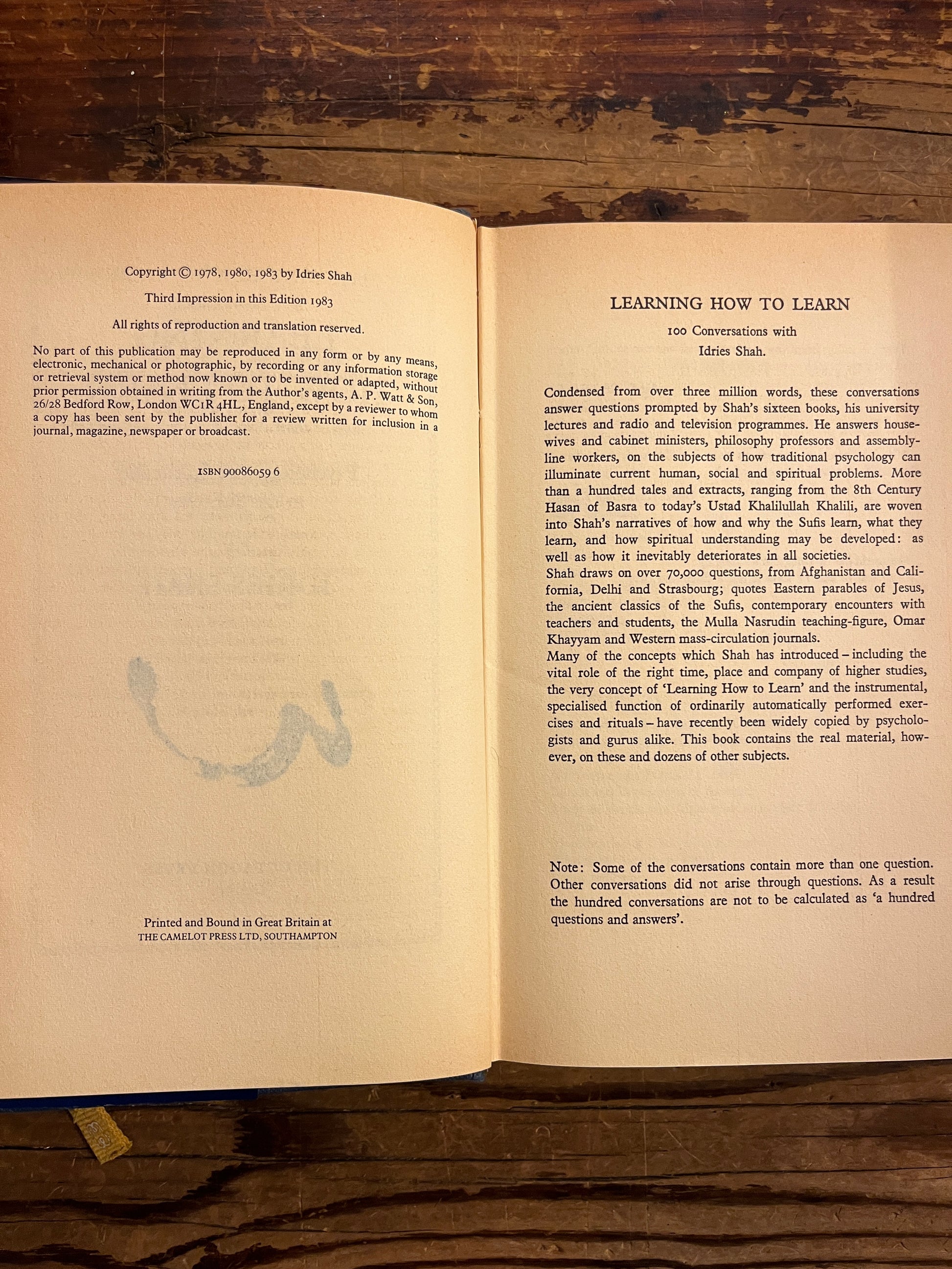 open boek with the title 'learning how to learn' by Idries Shah on a wooden surface
