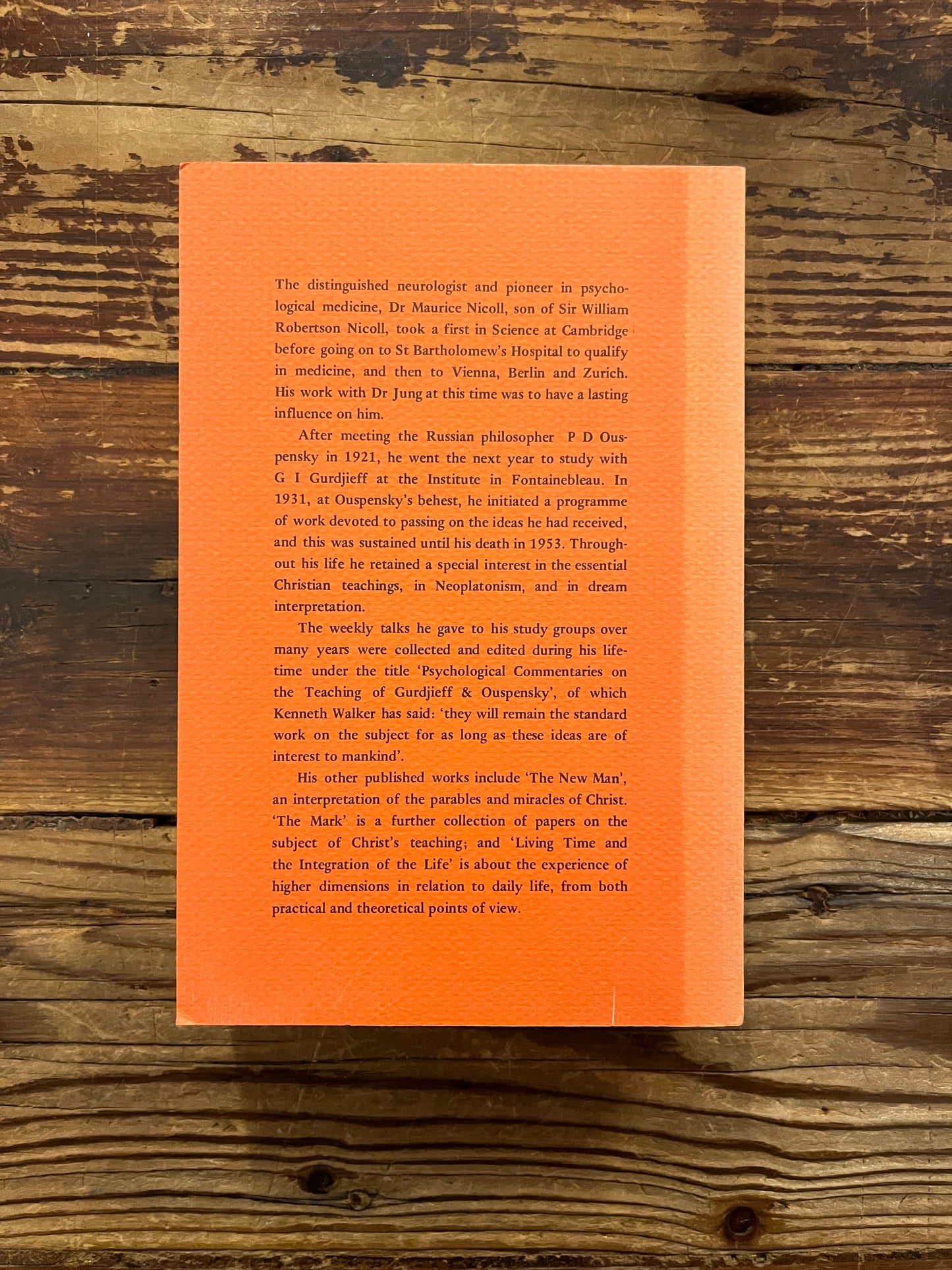 Back cover of book titled 'Psychological Commentaries on the Teaching of Gurdjieff & Ouspensky, volume 3' by Maurice Nicoll on a wooden surface.