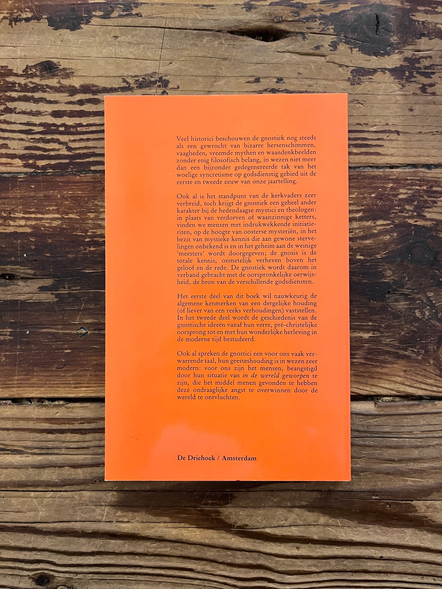 Achterkant van een boek met de titel 'De Gnosis' door Serge Hutin op een houten achtergrond