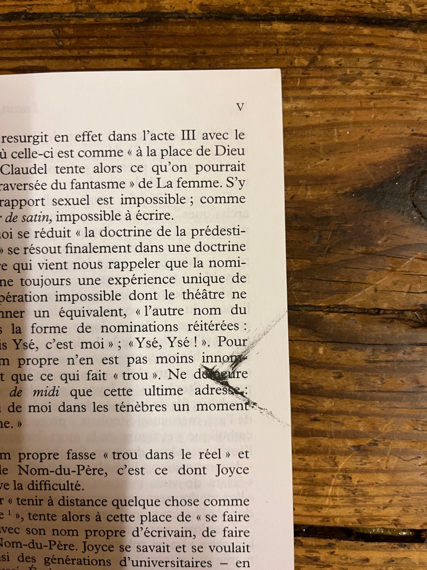 tache d'encre a la page quatre du livre  "lacan l'ecrit et l'image". livre pose sur fond de bois.