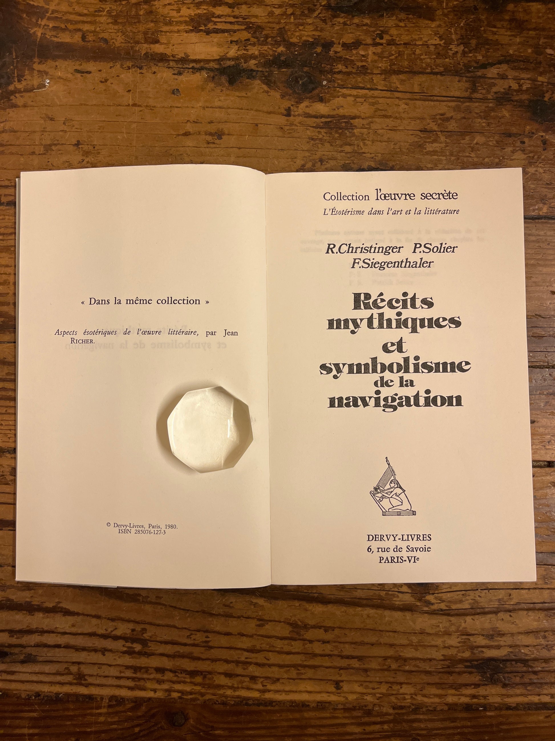 livres "Récits mythiques et symbolisme de la navigation"ouvert a la page de titresur fond de bois