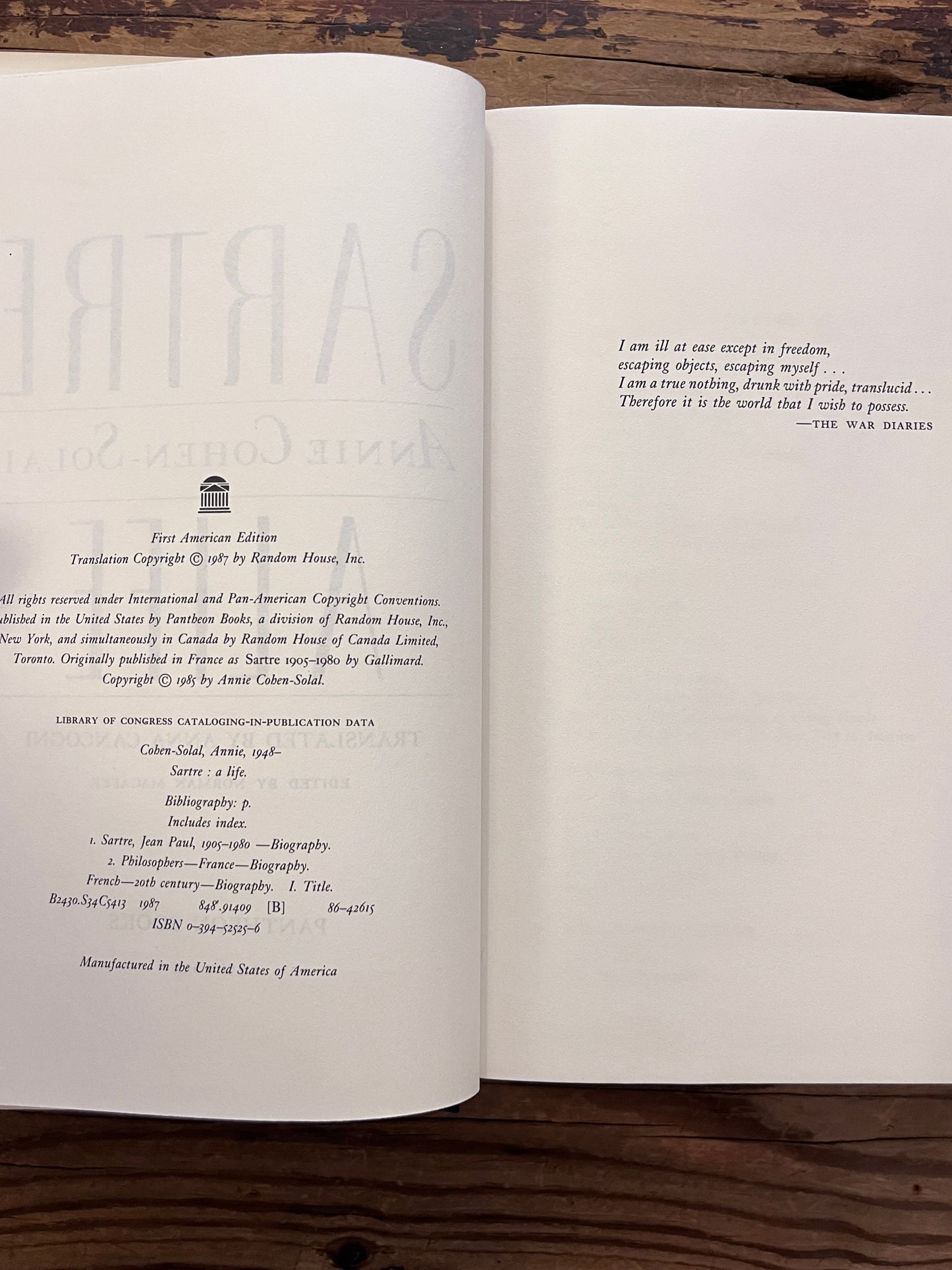 photo of the haldf title page of the book "sartre"on a wooden background