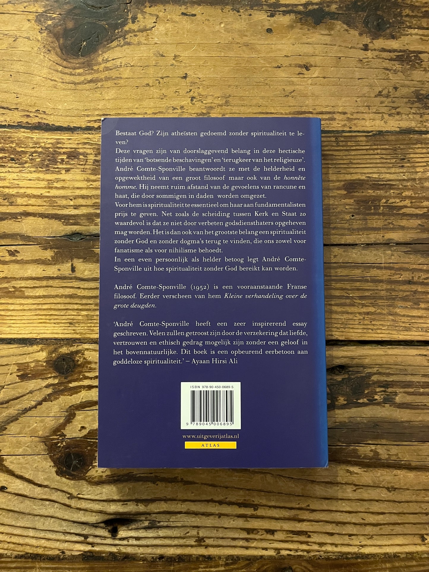 foto van de omslag van het boek "de geest van atheisme" op houten achtergrond