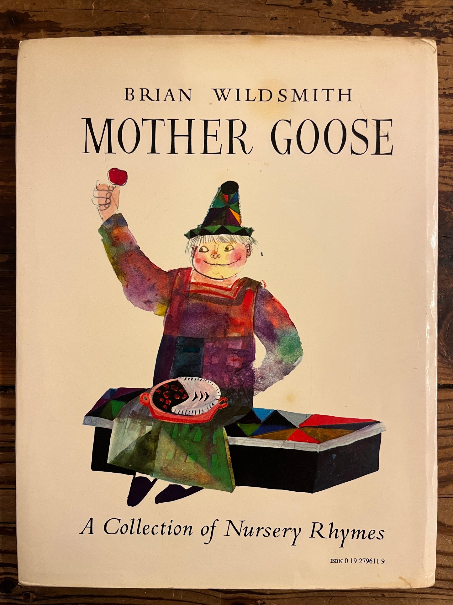 Back cover with dust-jacket of ook titled 'Mother Goose' by Brian Wild Smith on a wooden surface