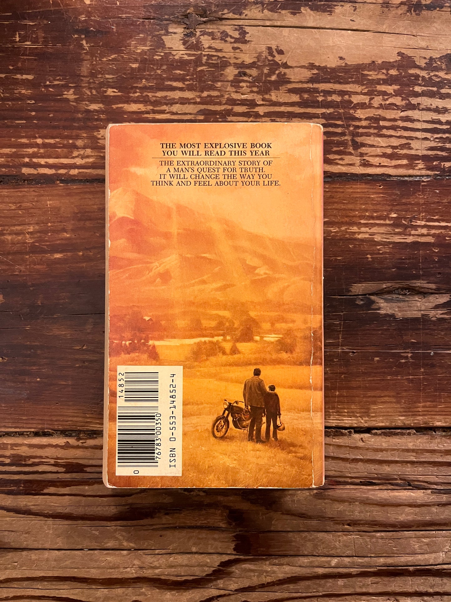 Back cover of book titled 'Zen and the Art of Motorcycle maintenance' by Robert M. Persig on a wooden surface