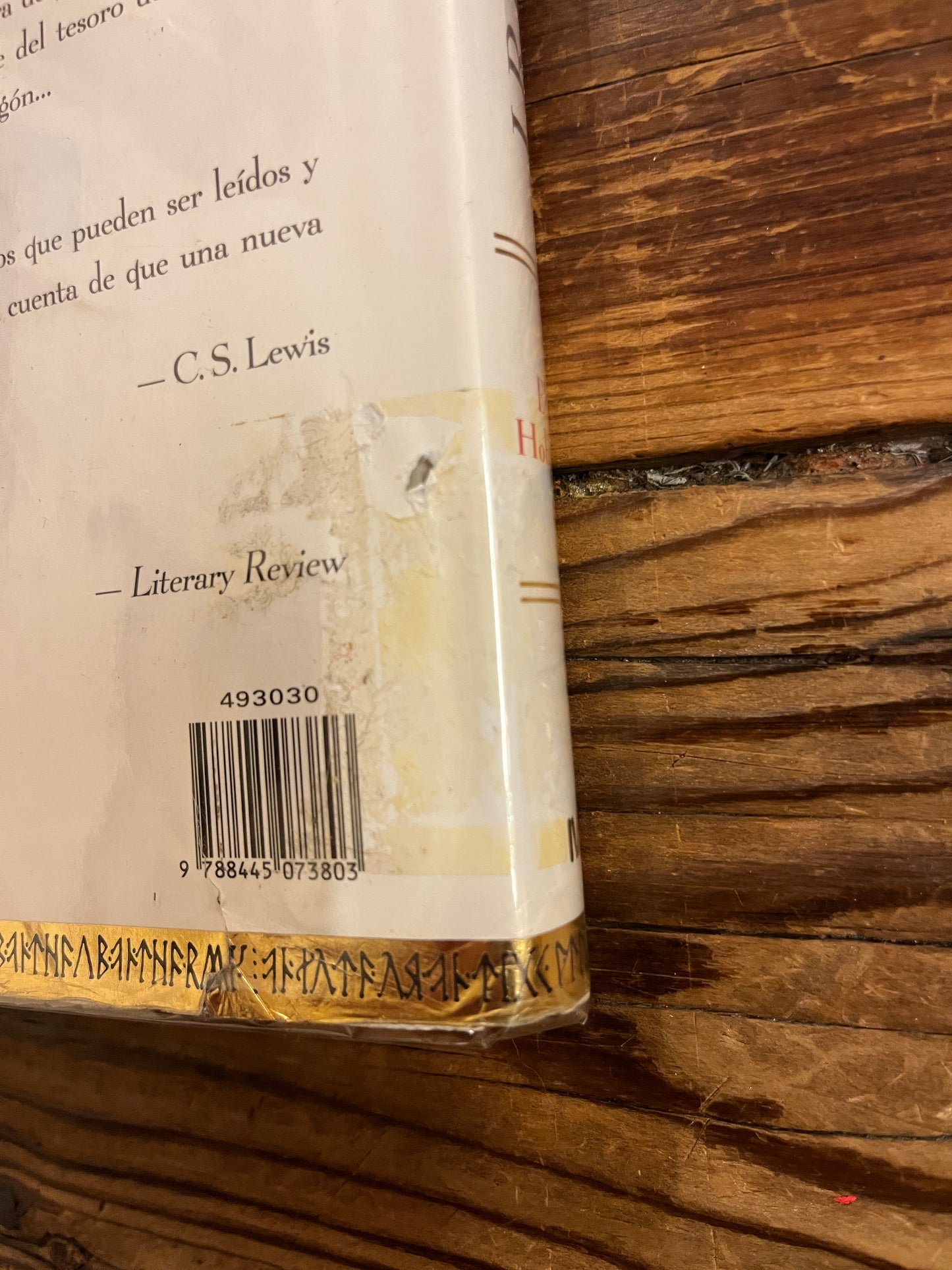 Close-up of a book with a visible barcode and text on a wooden surface