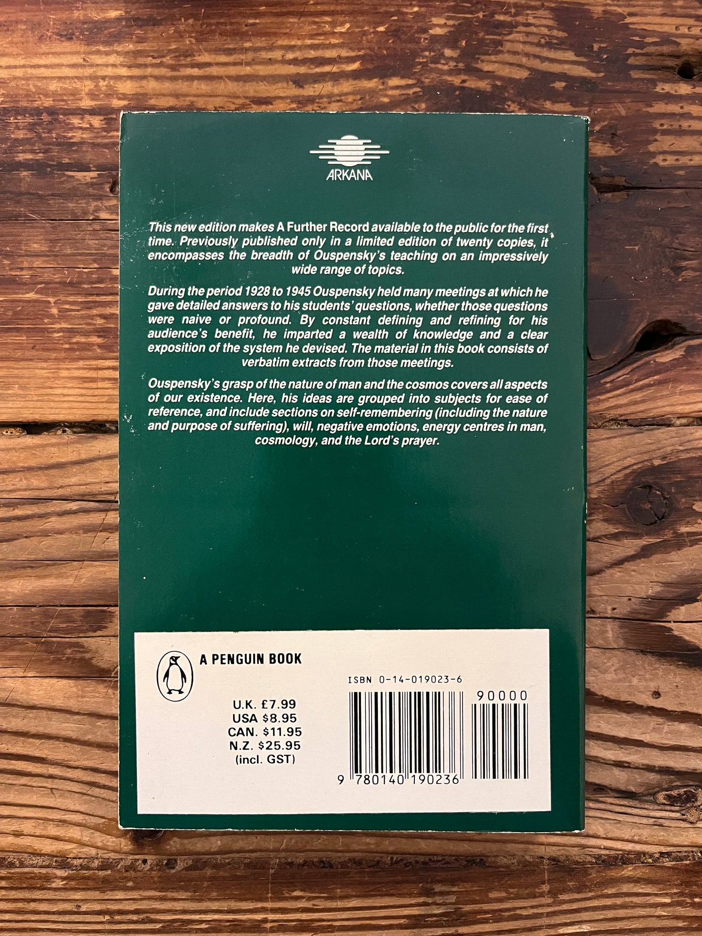 Back cover of book titled 'a further record' by P.D. Ouspensky on a wooden surface