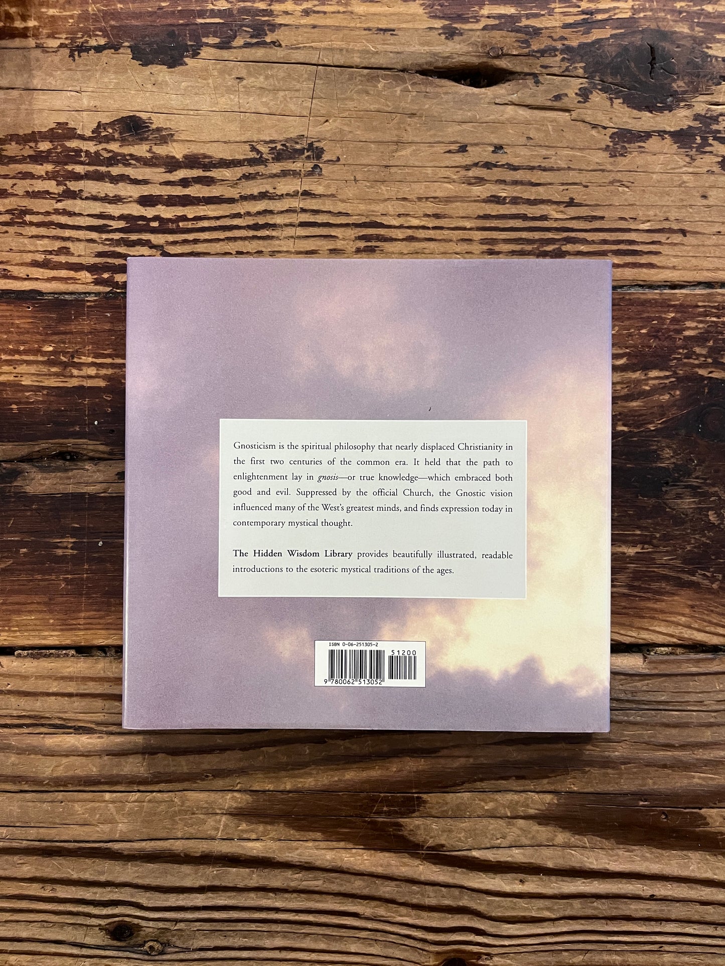 Back cover of a book titled 'Gnosticism: The Path of Inner Knowledge' by Martin Seymour-Smith on a wooden surface