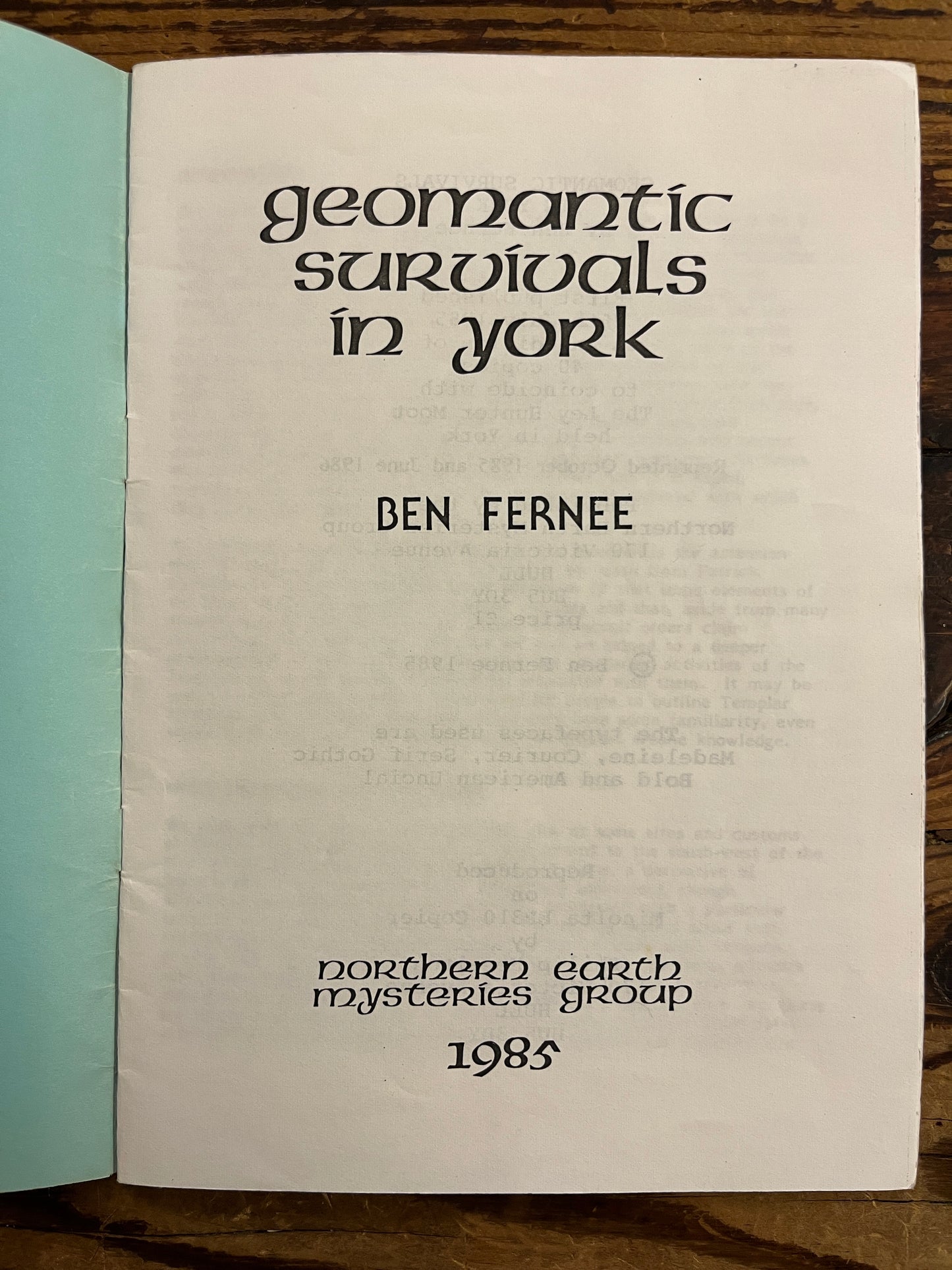 Book open on title page with text 'Geomantic survivals in York' by Ben Fernee on a wooden surface