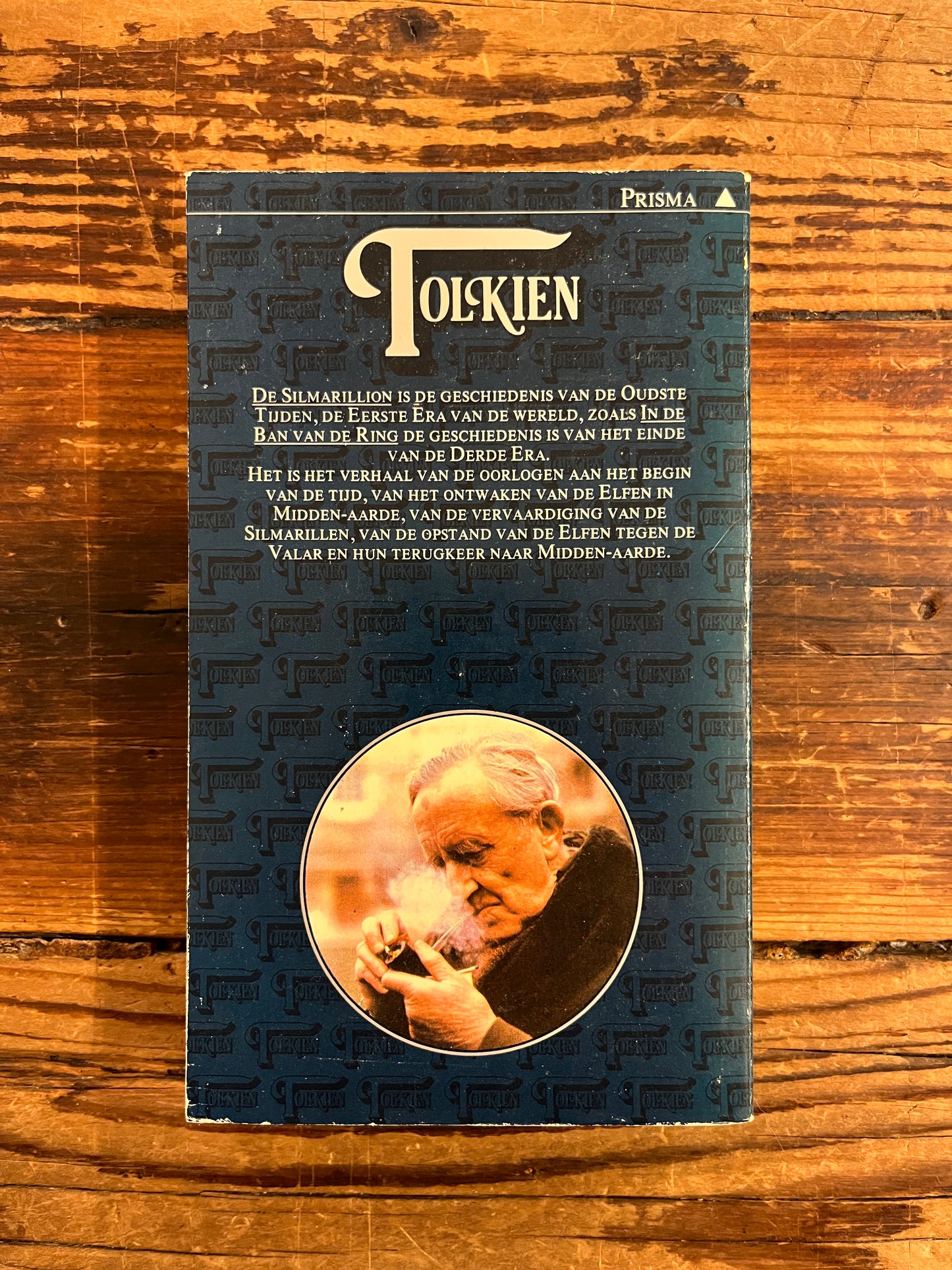 Achterkant van boek met de titel 'De Silmarillion' by J.R.R. Tolkien op een houten achtergrond