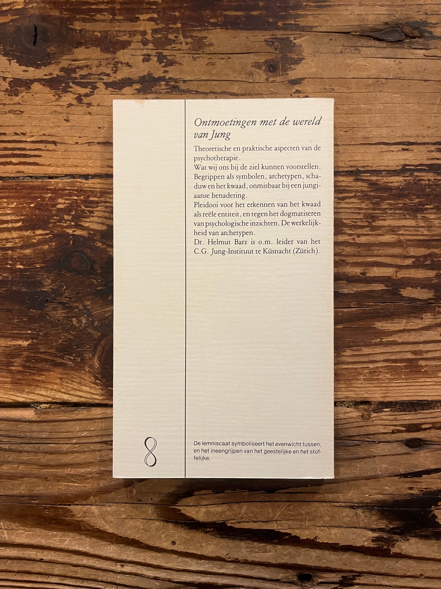 Boek met de titel 'Over de ziel, hoofdpunten in de jungiaanse psychotherapie' door H. Barz op een houten achtergrond
