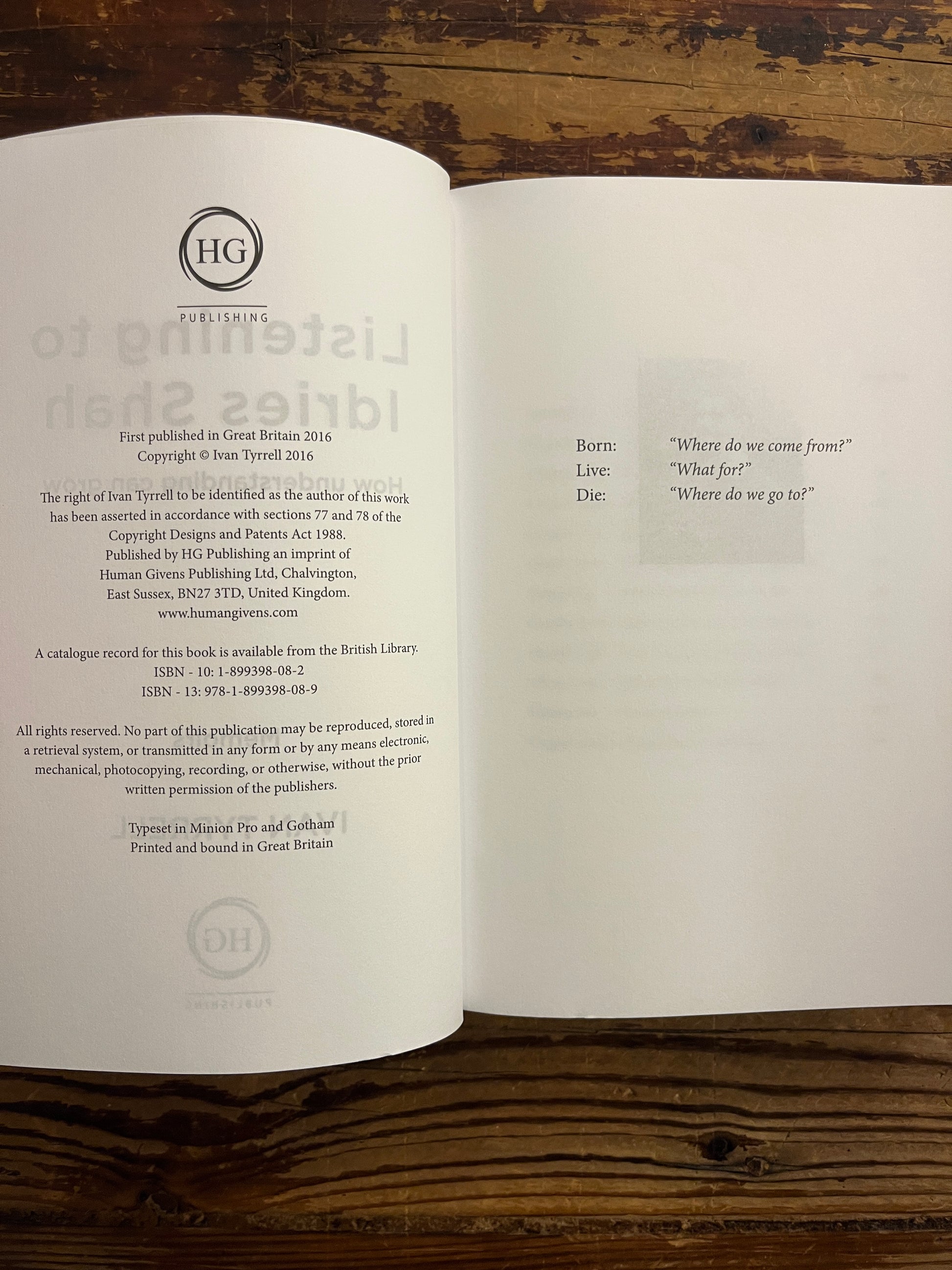 Open book titled 'Listening to Idries Shah' by Ivan Tyrrell on a wooden surface