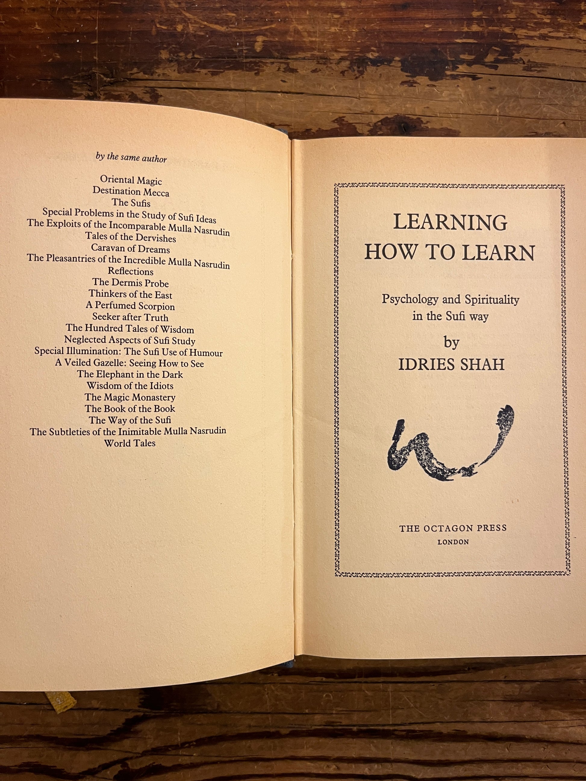 Open book with title page on a wooden surface