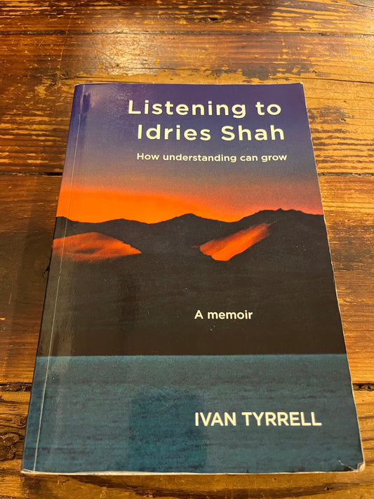 Book titled 'Listening to Idries Shah' by Ivan Tyrrell on a wooden surface