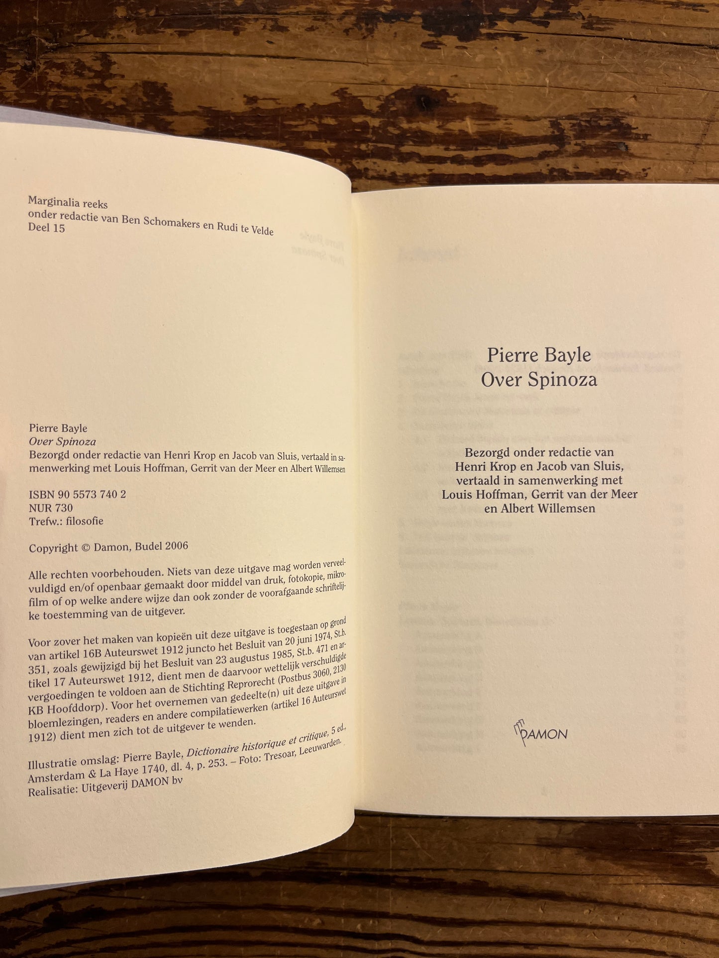 open boek met de titel 'Pierre Bayle over Spinoza' op een houten achtergrond