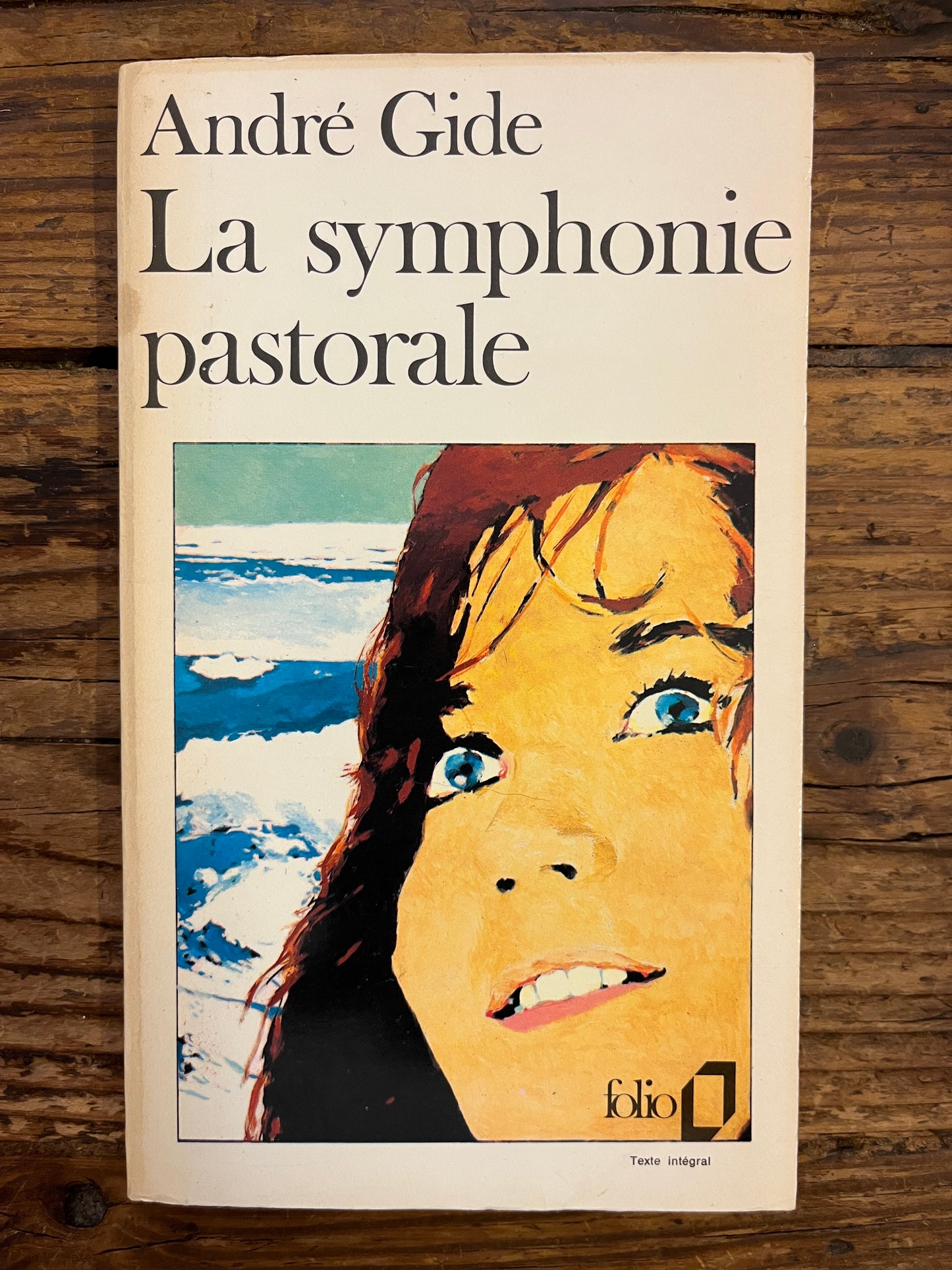 Couverture du livre 'La symphonie pastorale' par André Gide sur une surface en bois