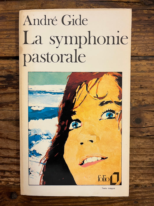 Couverture du livre 'La symphonie pastorale' par André Gide sur une surface en bois