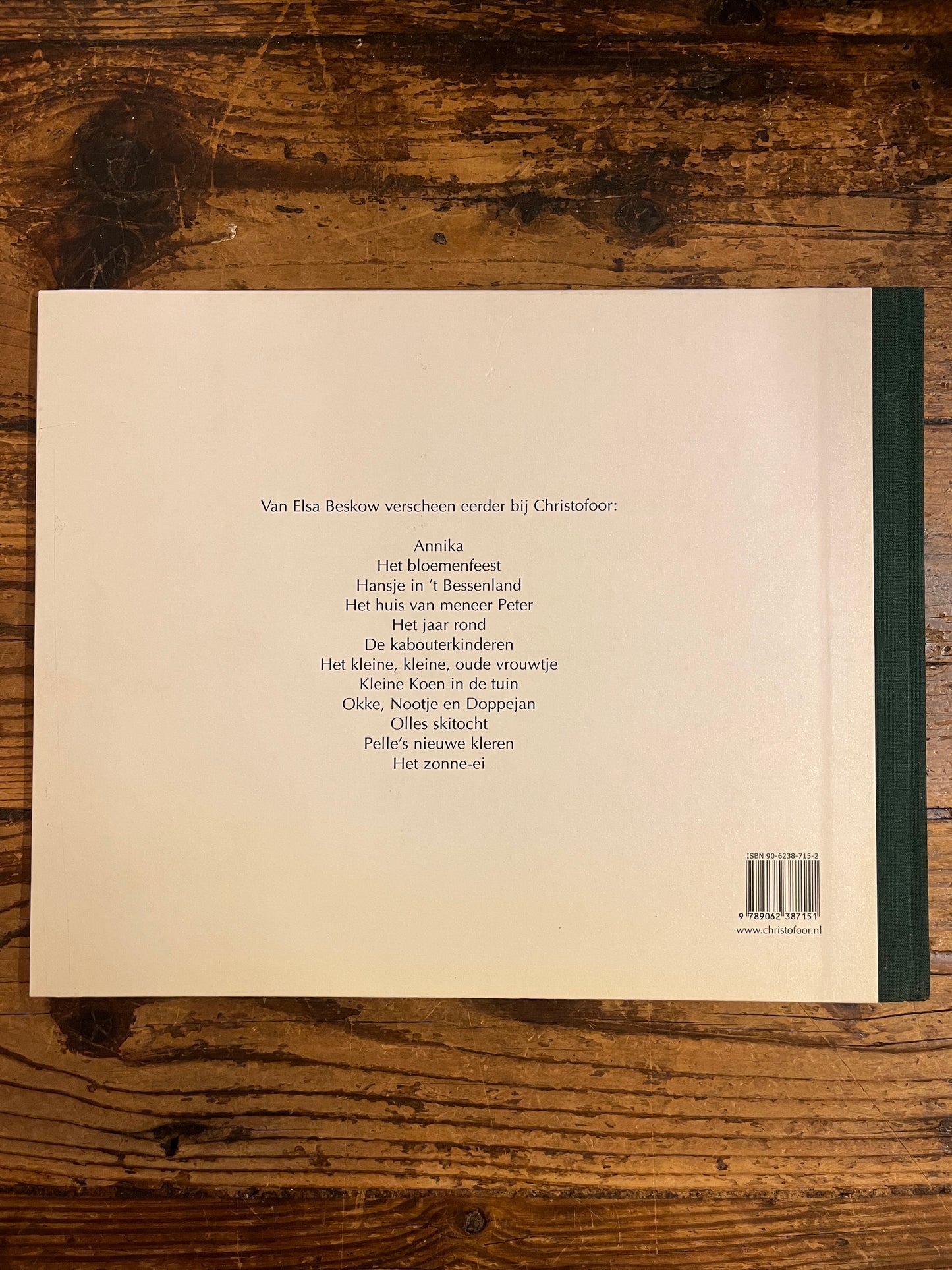 achterkant van het boek "peter en lisa vieren kerstfeest" op houten achtergrond