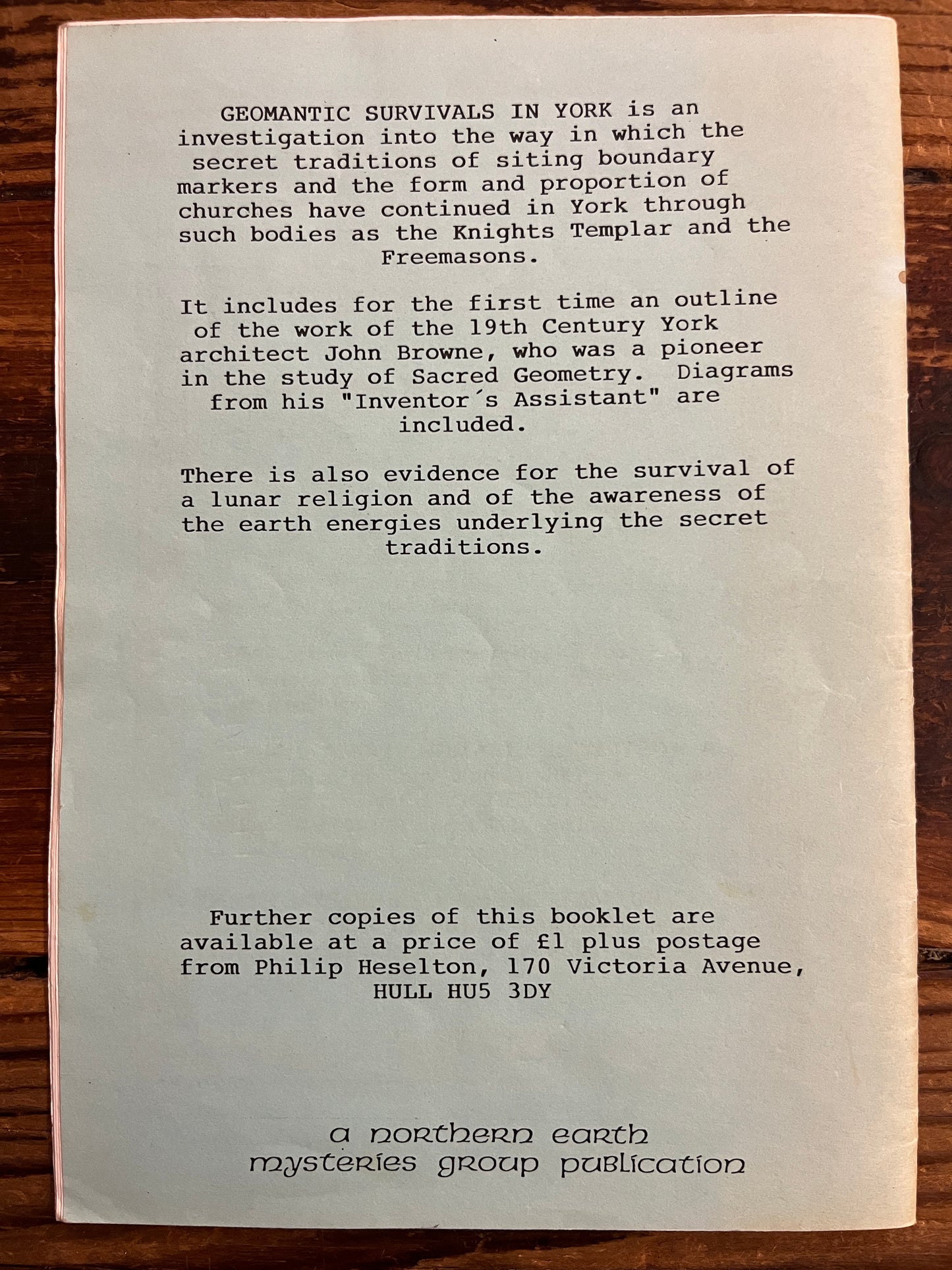 back cover of a booklet with text on a wooden surface