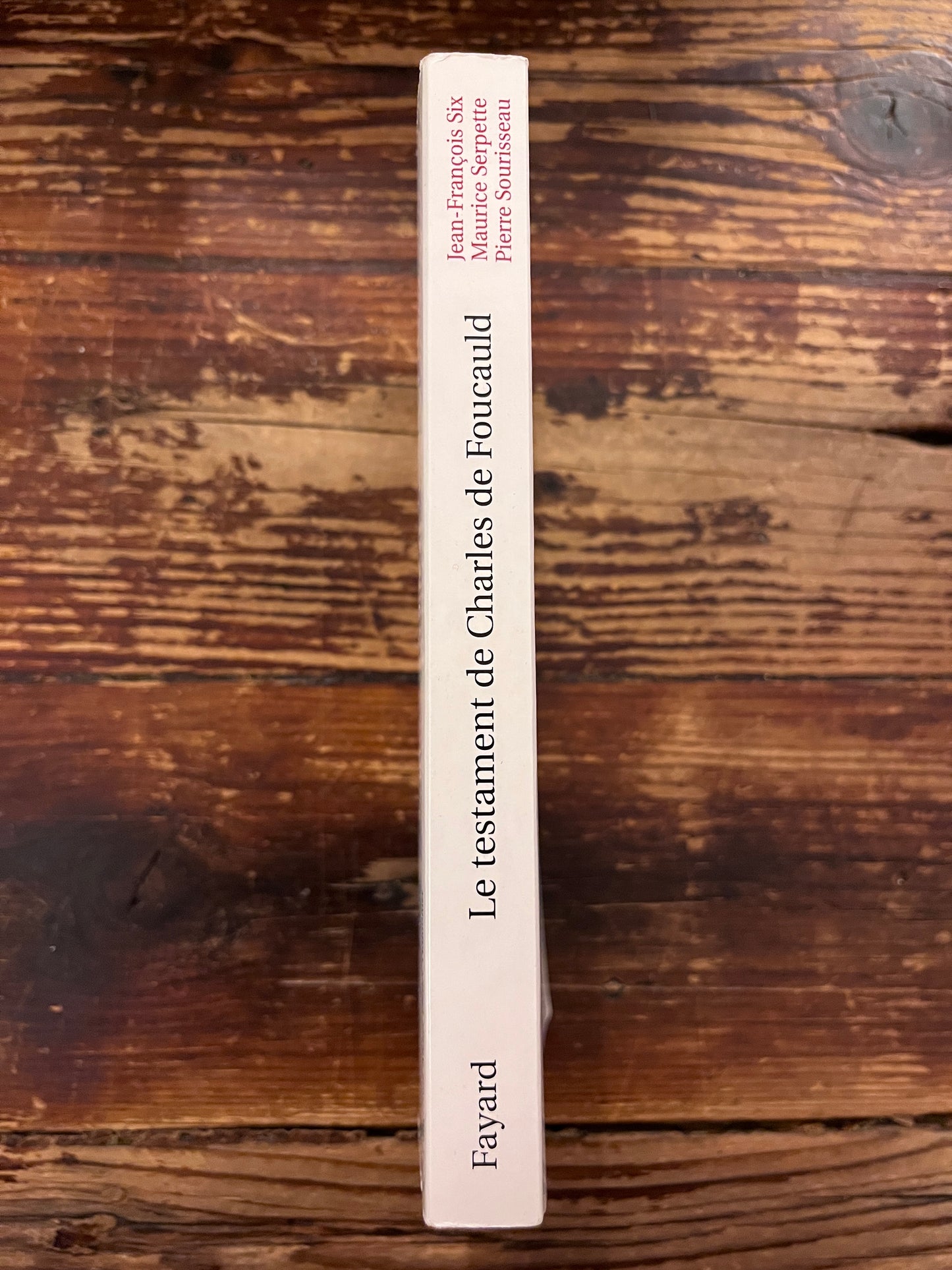 photo du dos du livre "le testament de charles de foucauld"sur fond de bois