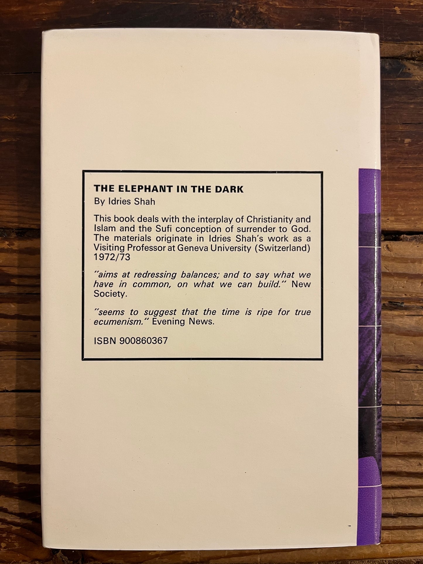 Back cover titled 'the elephant in the dark' by Idries Shah on a wooden surface