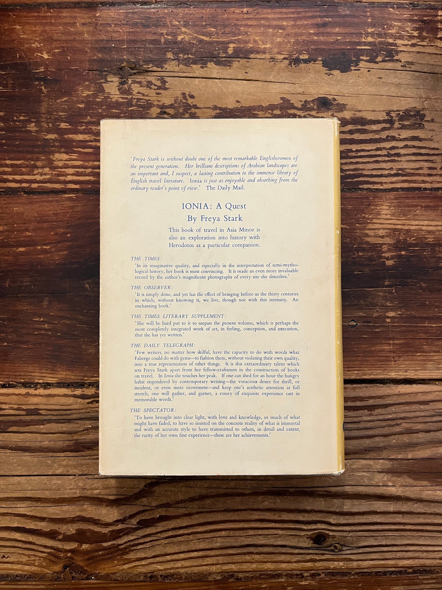 Back cover of book titled 'The Lycian Shore' by Freya Stark on a wooden surface