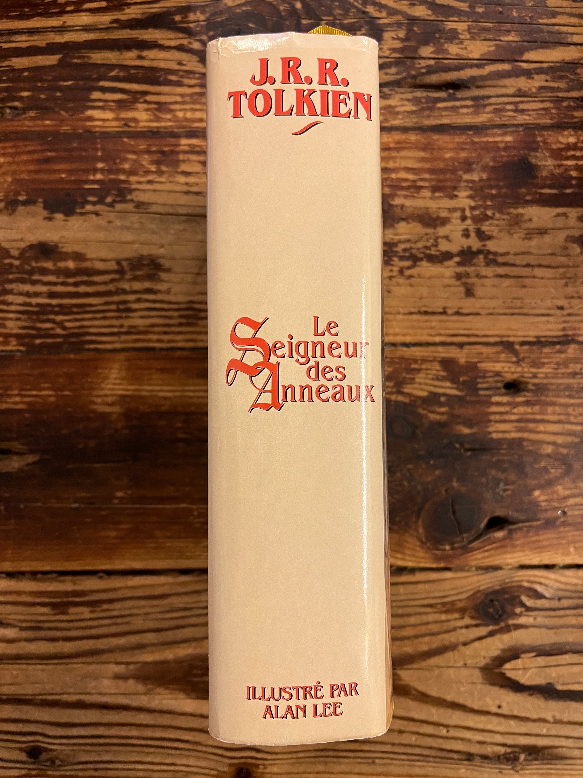 Tranche du livre avec jaquette 'le seingeur des Anneaux' par Tolkien sur une surface en bois