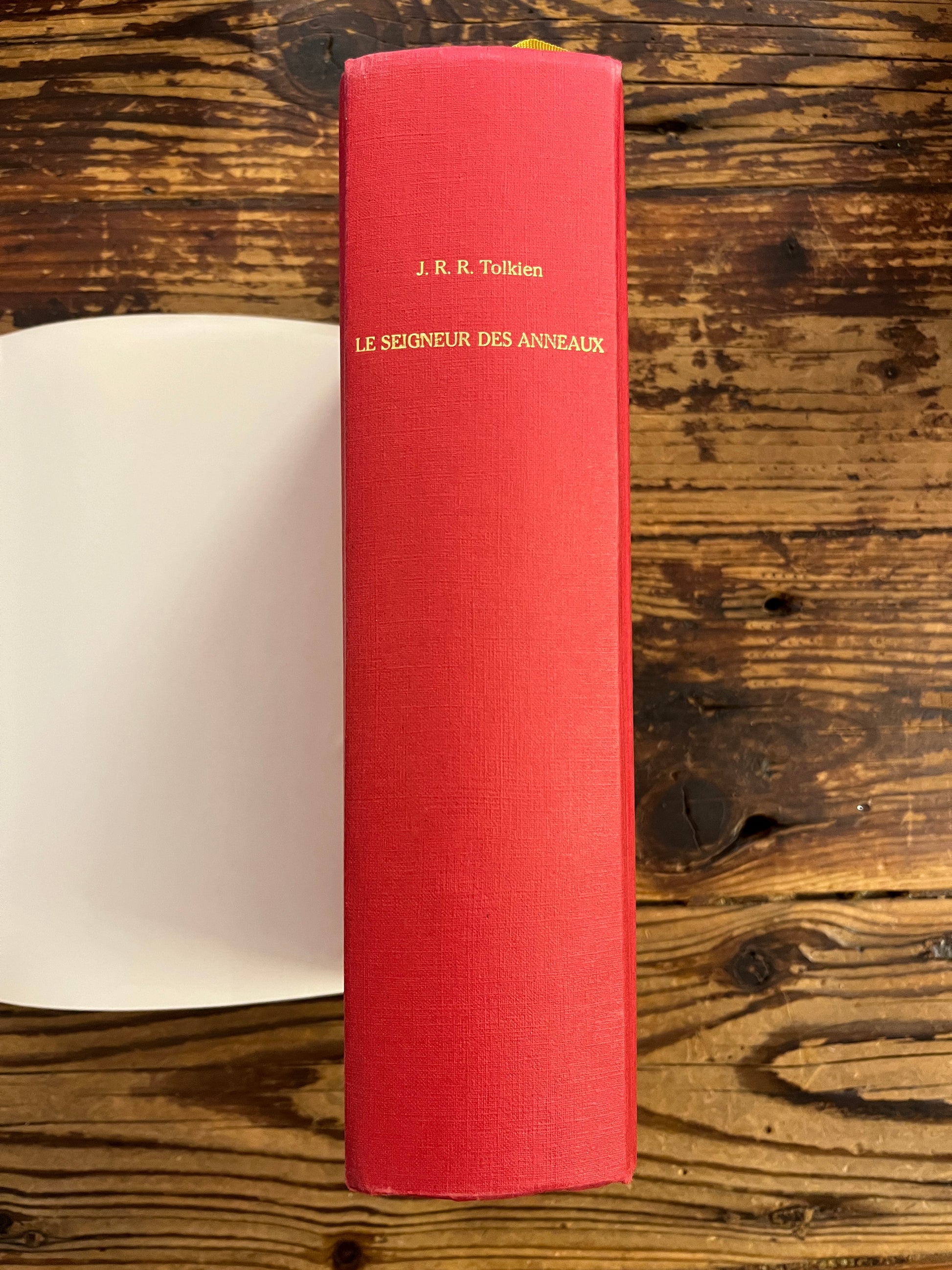 tranche du livre 'le seigneur des anneaux' par Tolkien sur une surface en bois