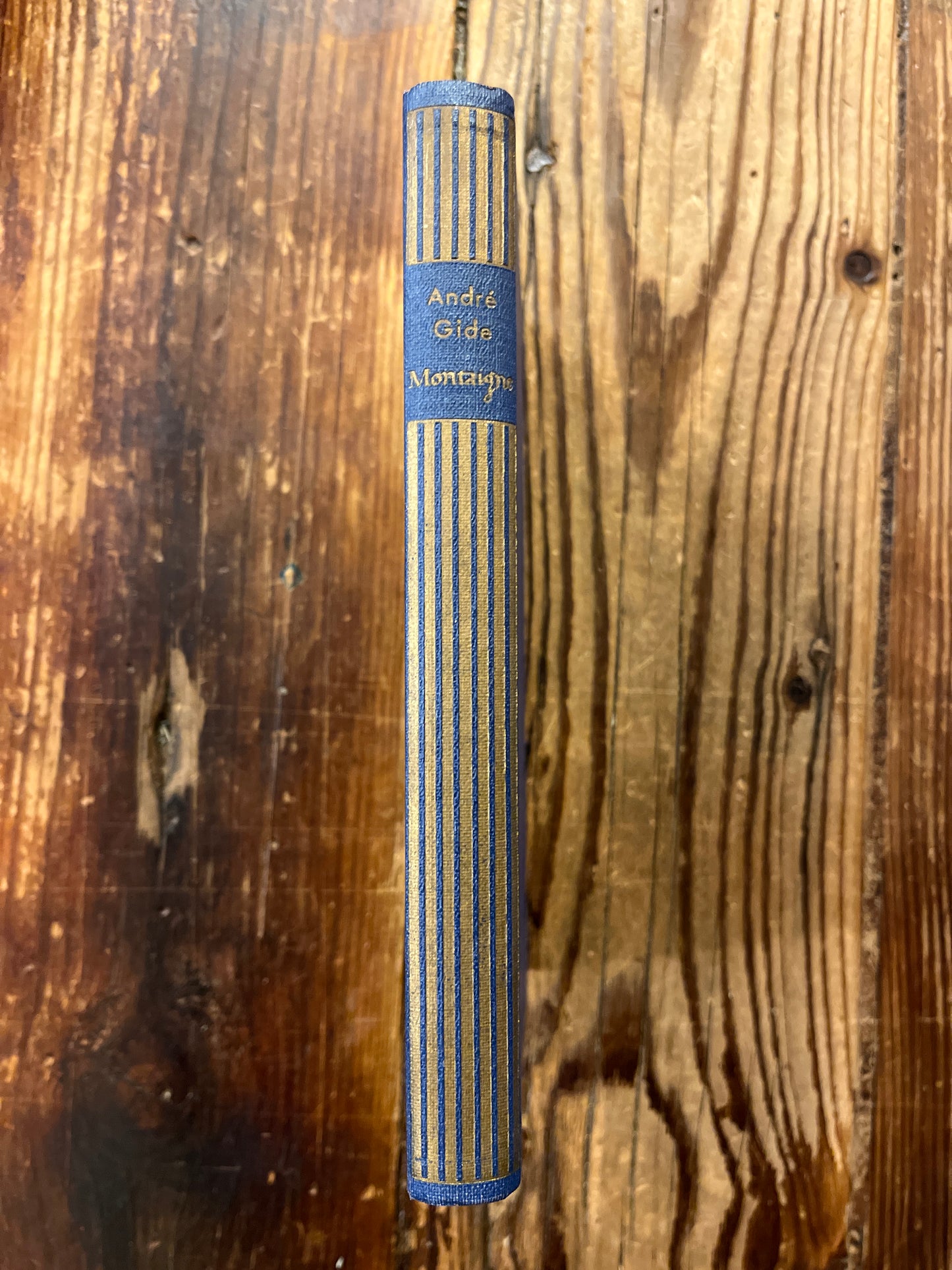 rug van een boek met de titel 'Montaigne' door André Gide op een houten achtergrond