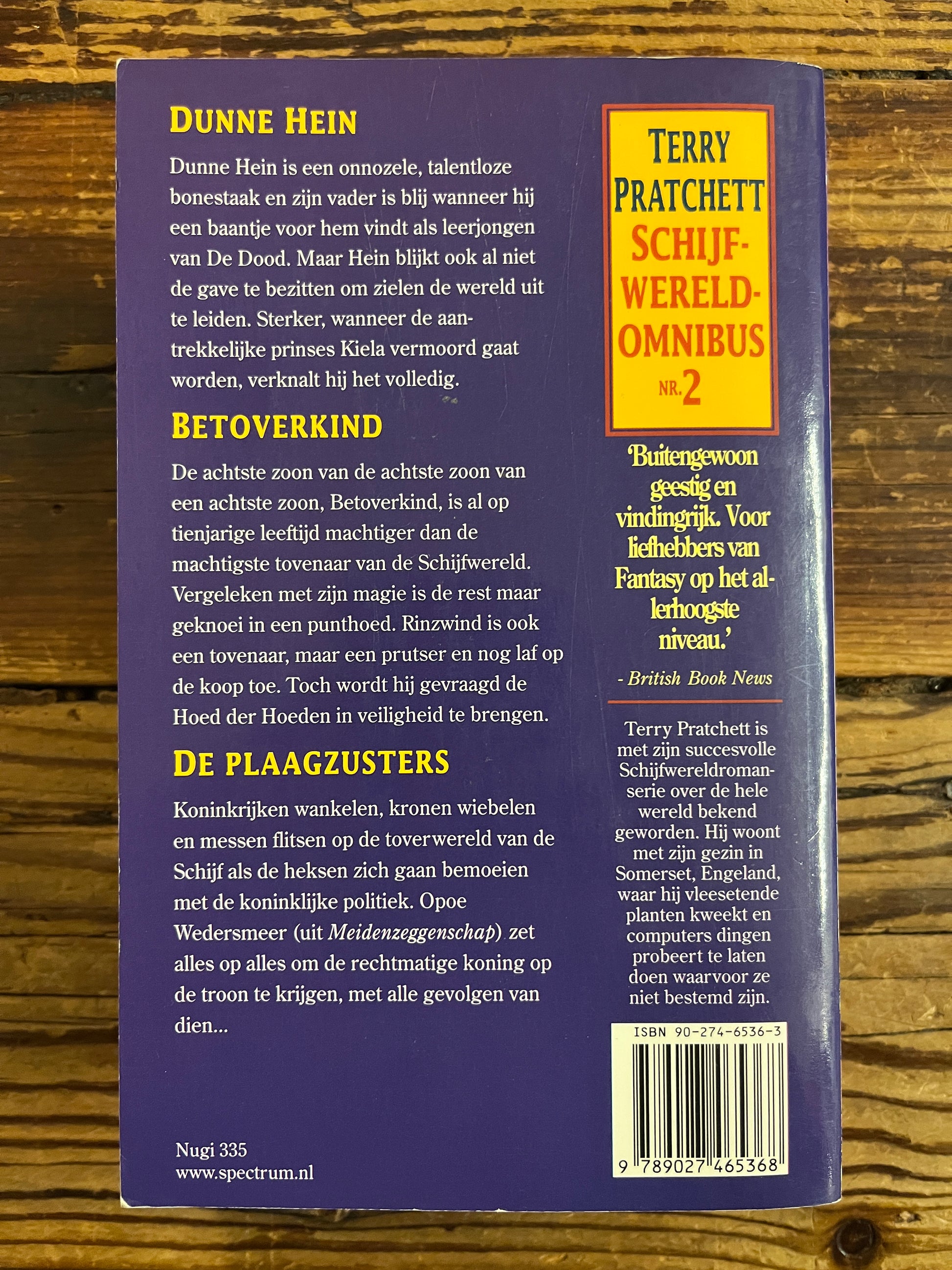 Achterkant van boek met titel 'Terry Pratchett Schijfwereld Omnibus No. 2' op een houten achtergrond