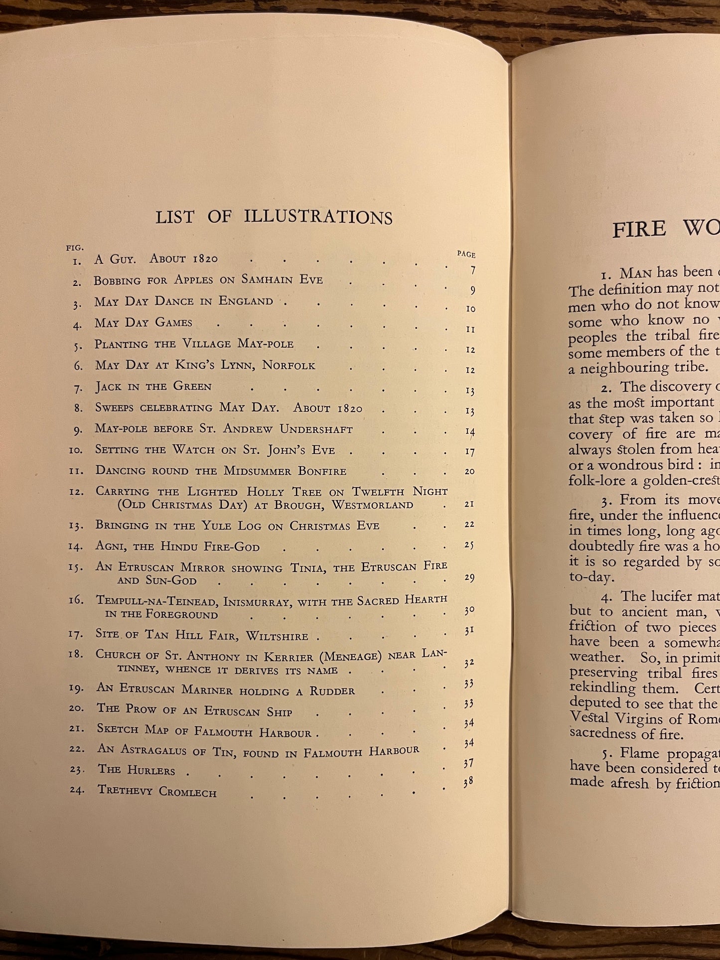 Open book with text and a list of illustrations in a booklet called 'fire worship in Britain' on a wooden surface