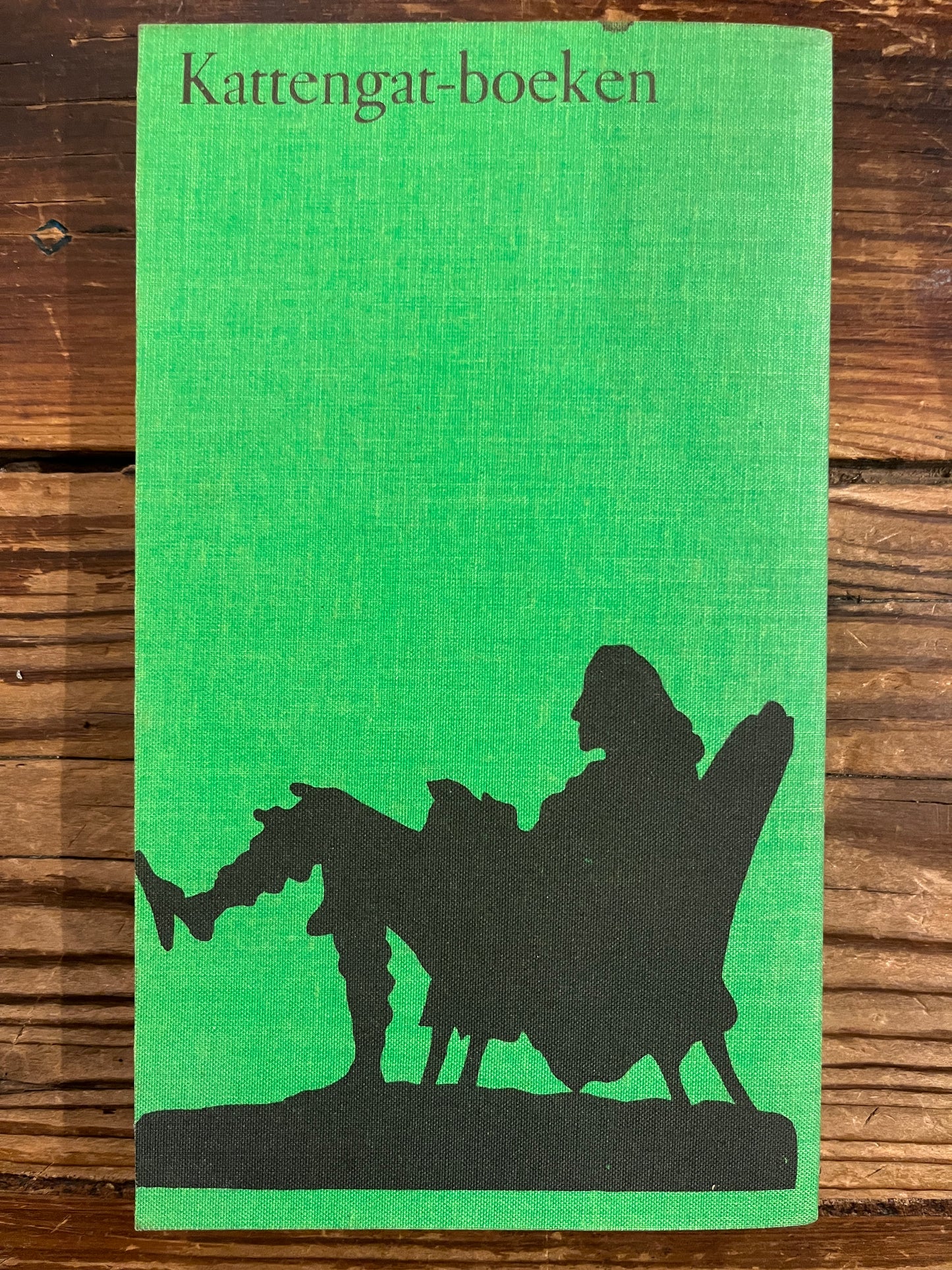 Achterkant van boek met de titel 'Filosofisch woordenboekje' door Voltaire op een houten achtergrond