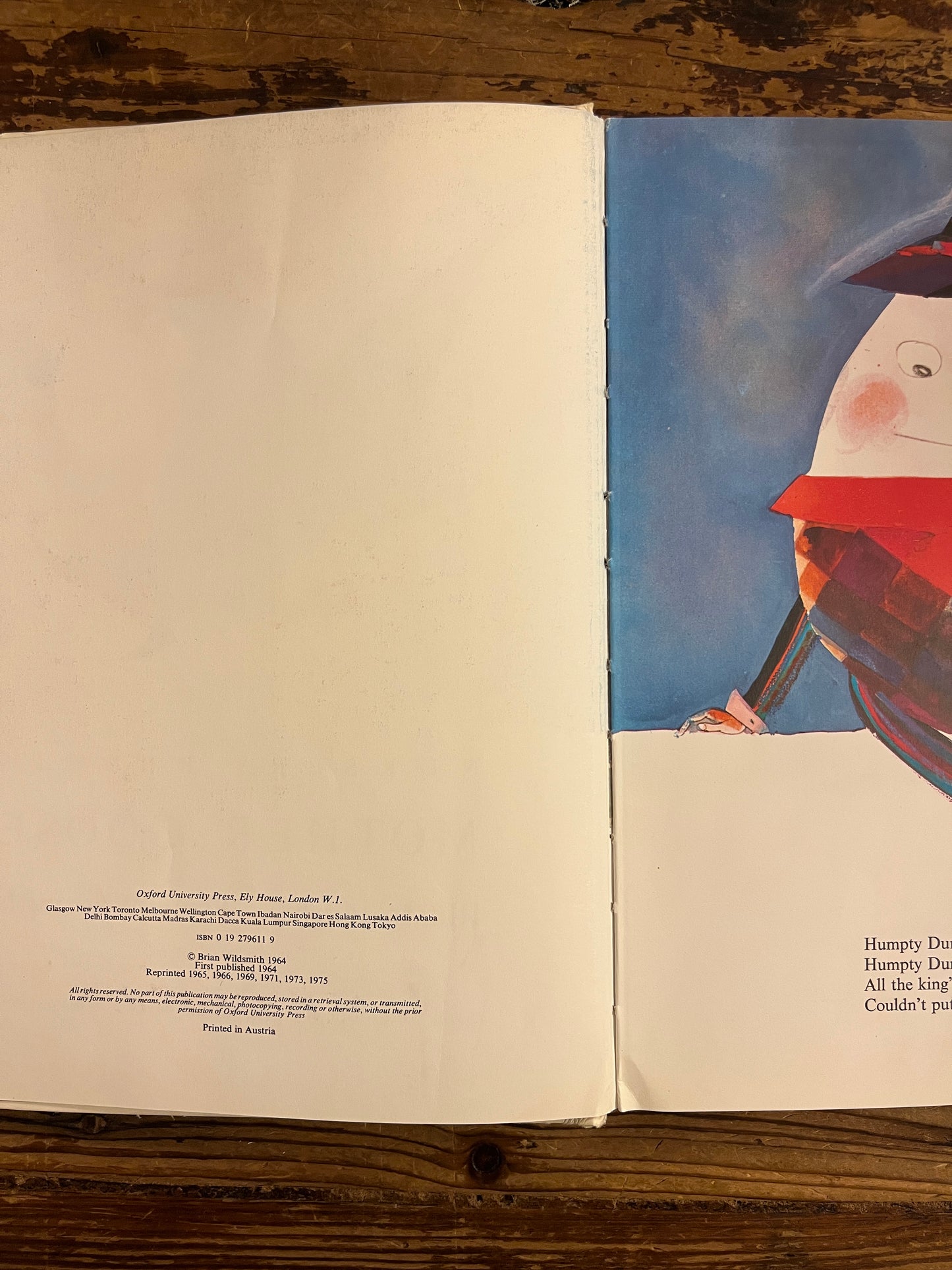 Open Book titled 'Mother Goose' by Brian Wild Smith on a wooden surface with a colorful illustration on a wooden surface