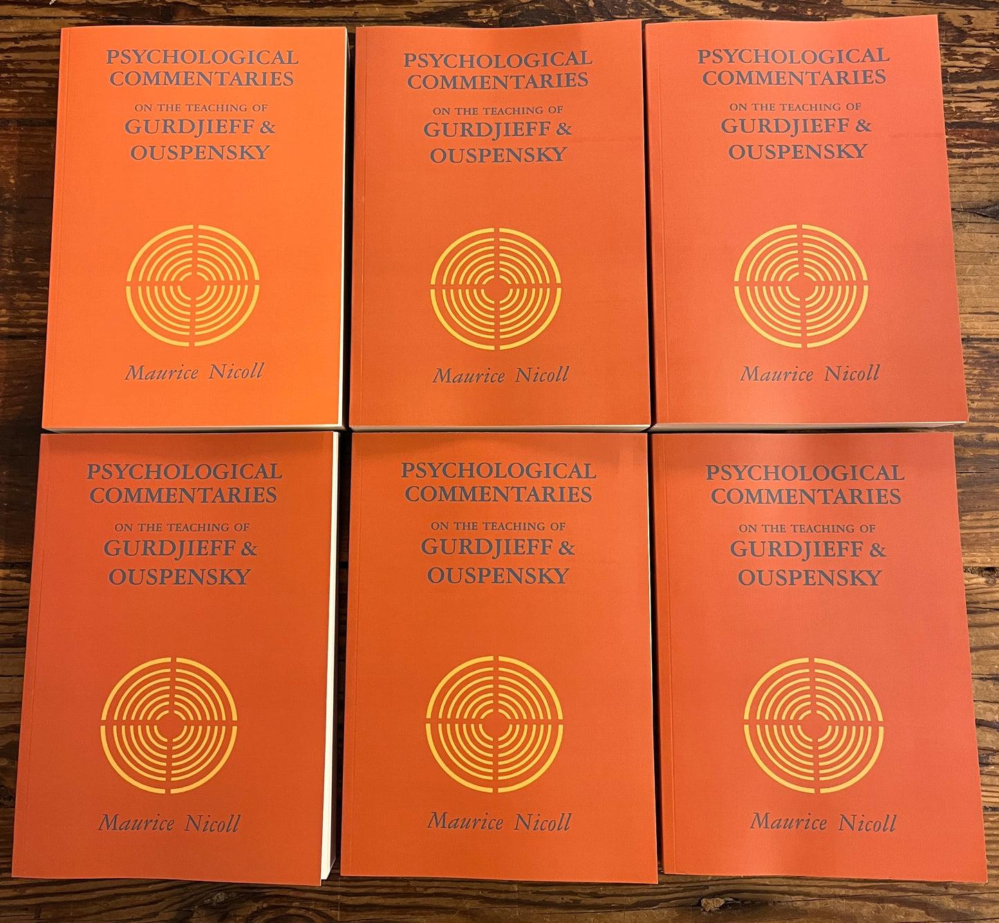 Six books titled 'Psychological Commentaries on the Teaching of Gurdjieff & Ouspensky' by Maurice Nicoll on a wooden surface.
