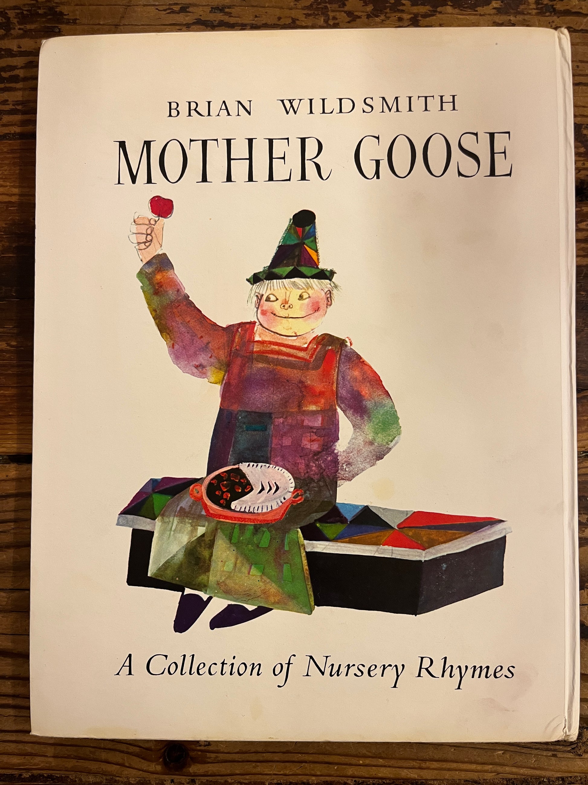 back cover  without dust-jacket of Book titled 'Mother Goose' by Brian Wild Smith on a wooden surface