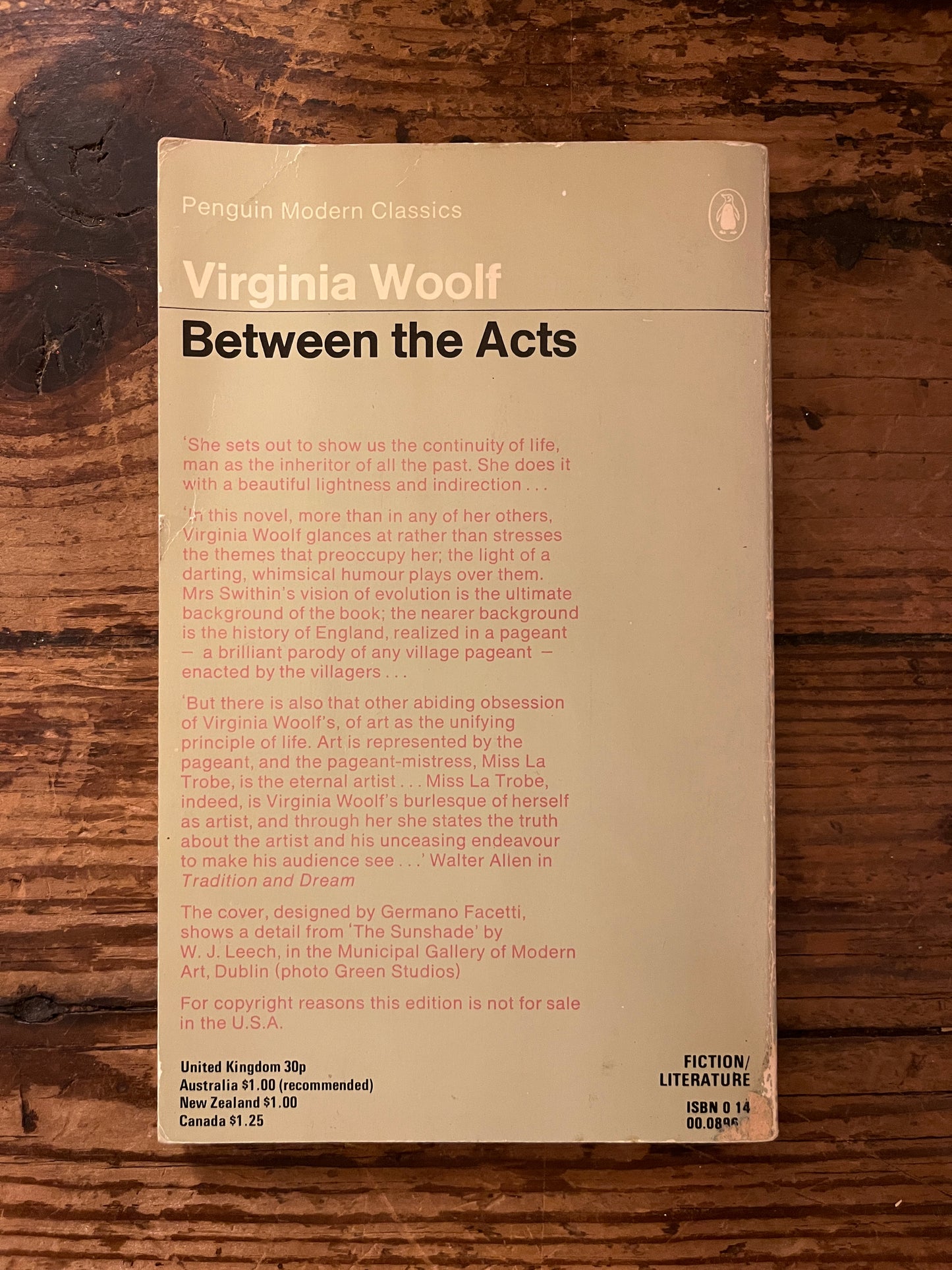photo of the backcover of the book "between the acts" on a wooden background
