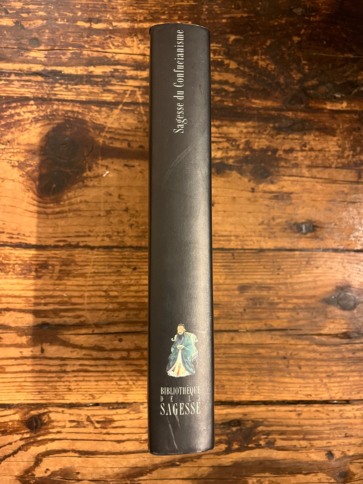 photo du dos du livre "sagesse du confucianisme" sur fond de bois