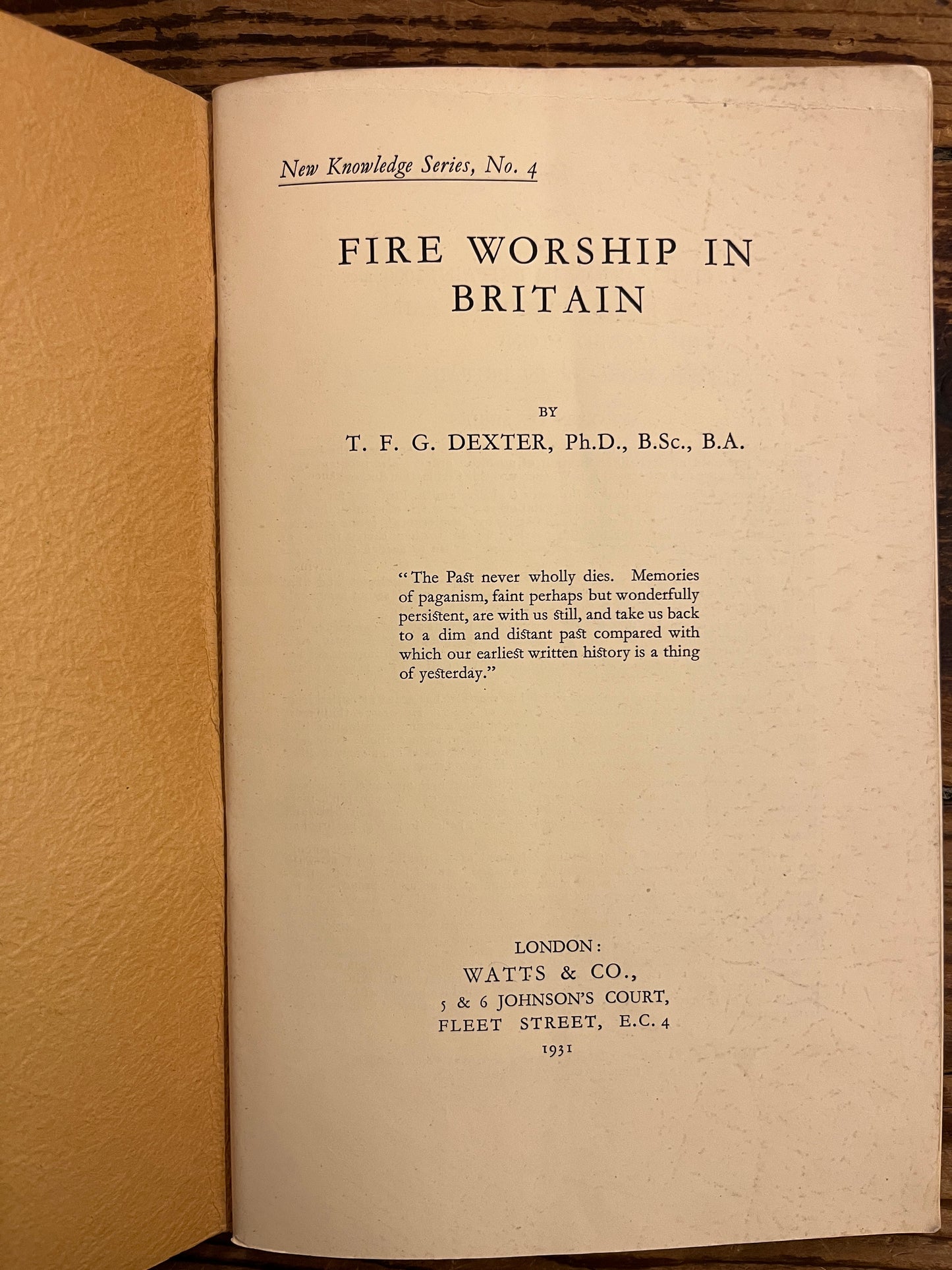 Open book titled 'Fire Worship in Britain' by T.E.G. Dexter on a wooden surface