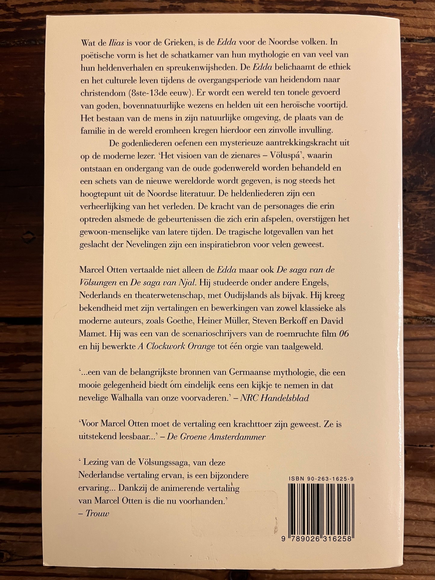 Back cover of a book with text and a barcode on a wooden surface