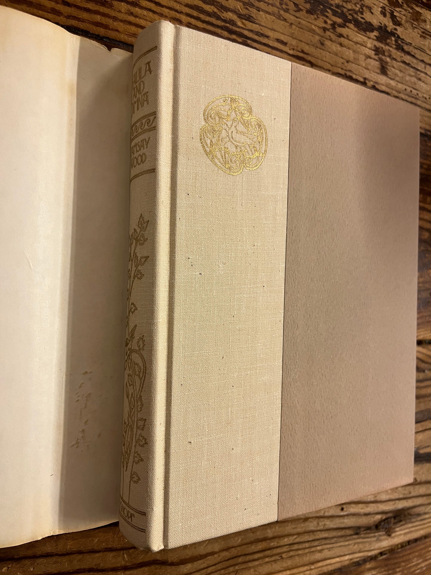 Spine a front cover view of book without dust jacket titled 'Kalila and Dimna, selected Fable of Bidpai' retold by Ramsay Wood, on a wooden surface