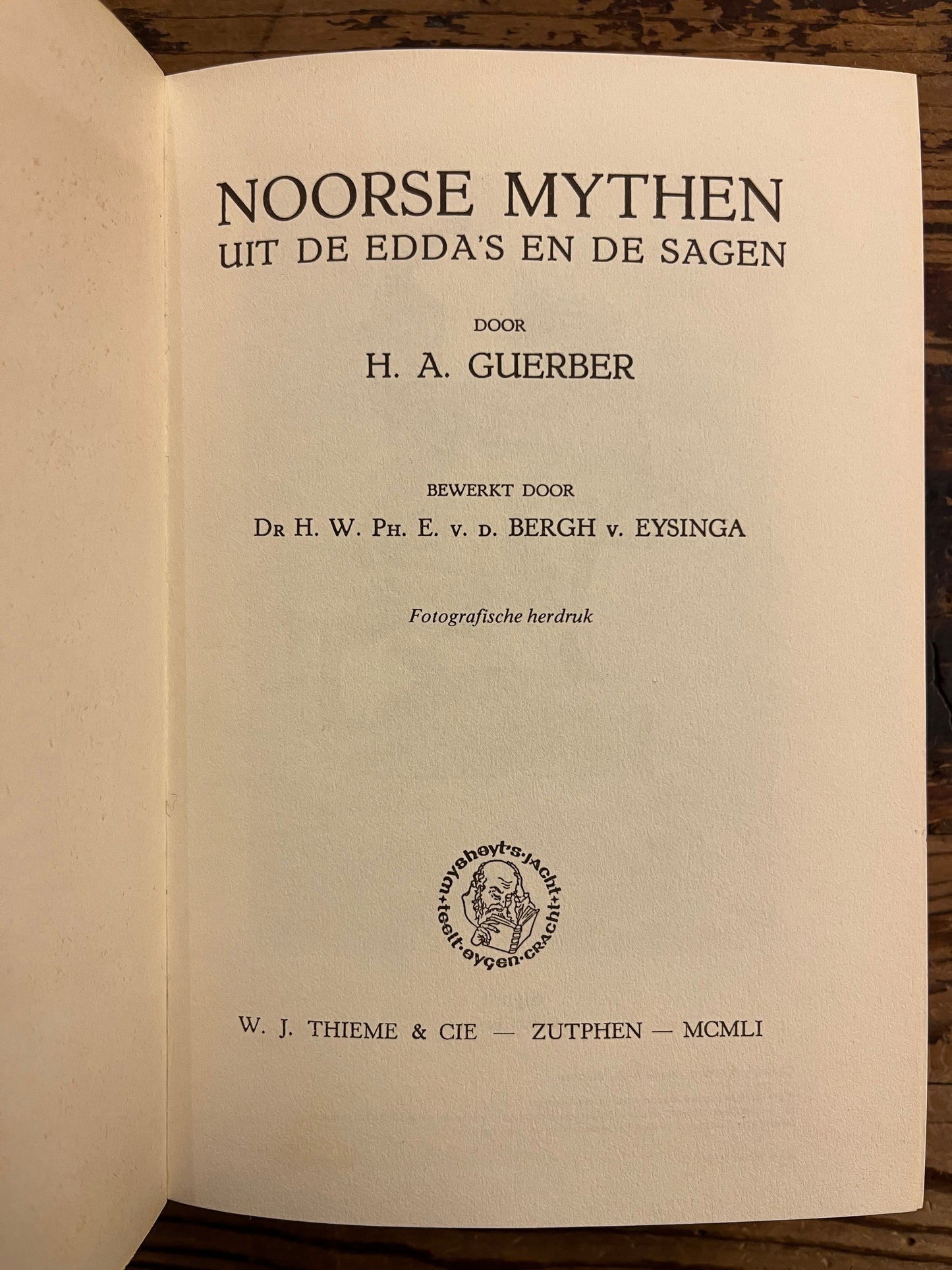 Open book with title page visible on a wooden surface