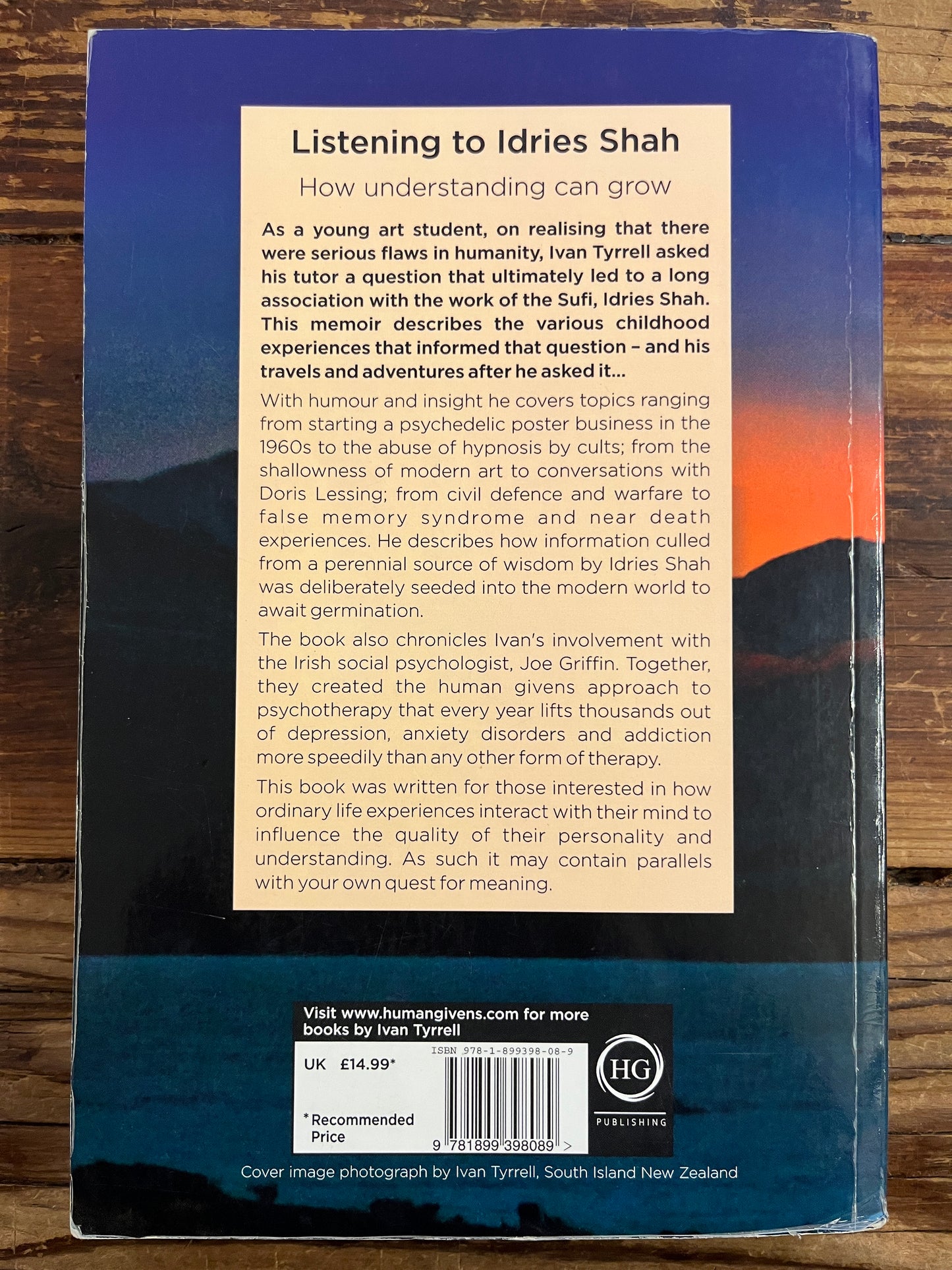Back cover of a book  titled 'Listening to Idries Shah' by Ivan Tyrrell on a wooden surface