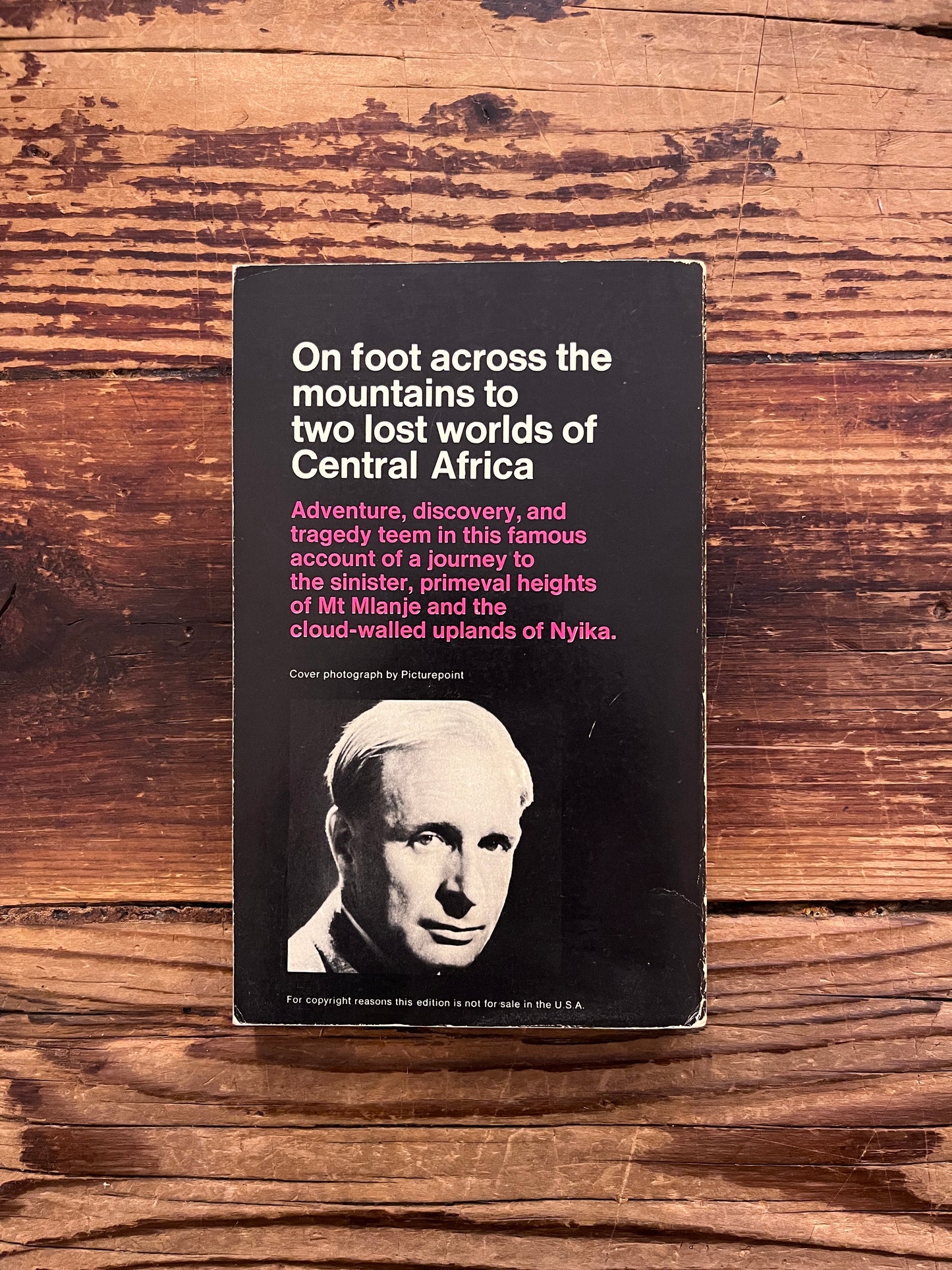 Back cover book titled 'venture to the interior' by Laurens van der Post on a wooden surface