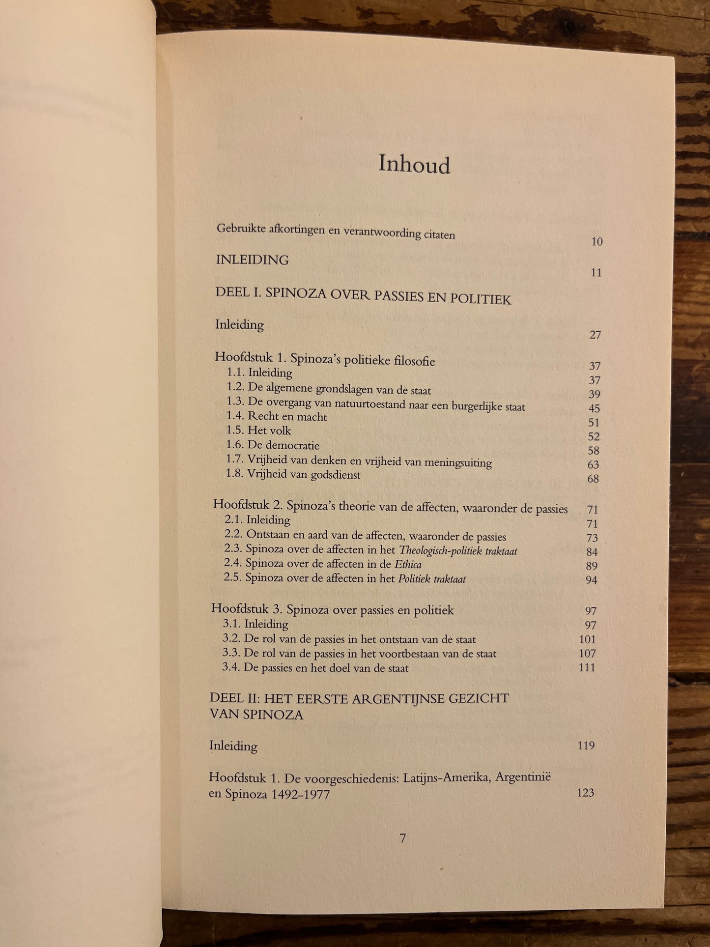 Open boek met de titel 'het Argentijnse gezicht van Spinoza' door Miriam van Reijen op een houten achtergrond