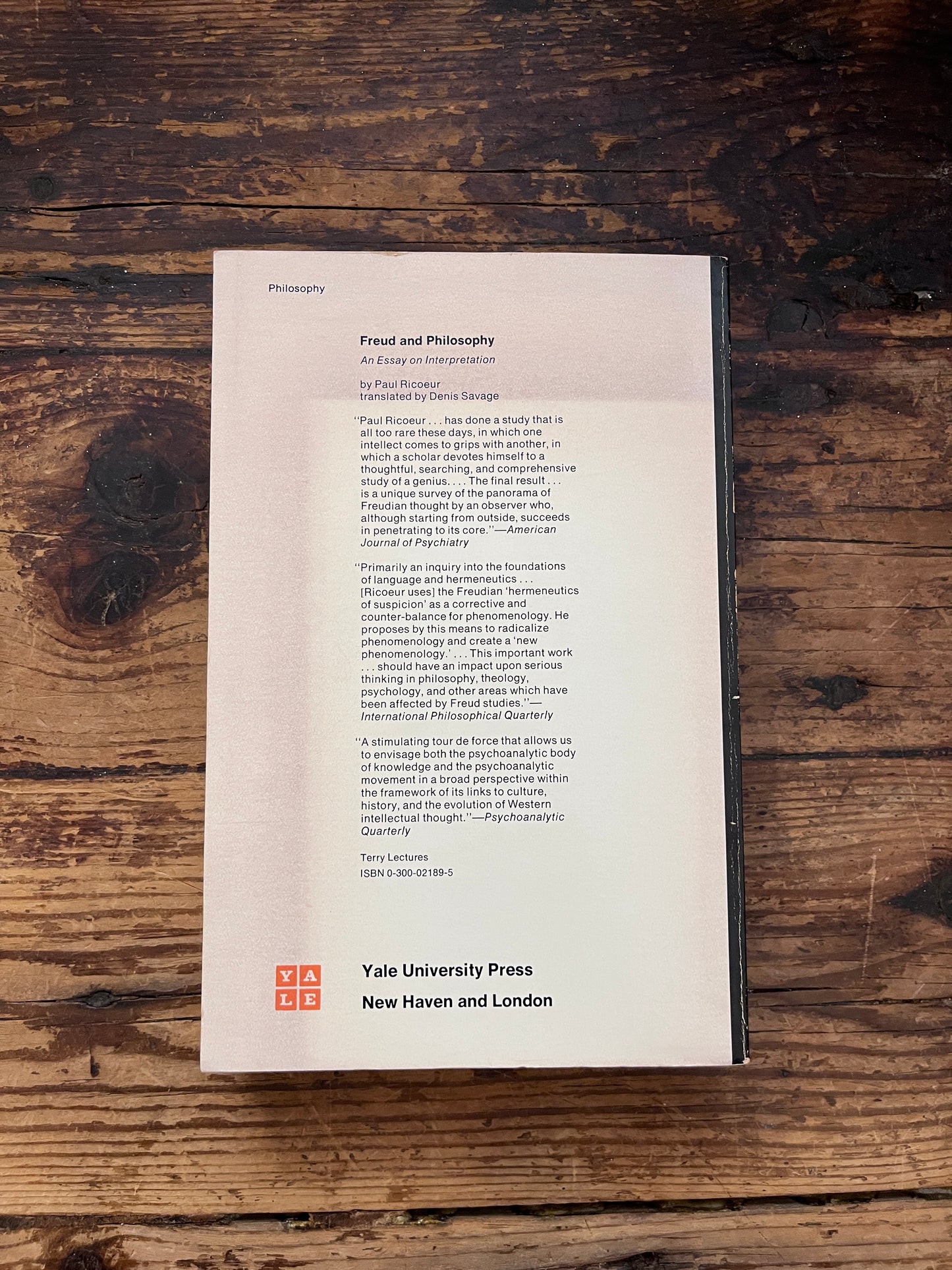 photo of the backcover of the book of the book "Freud and philosophy" on a wooden background
