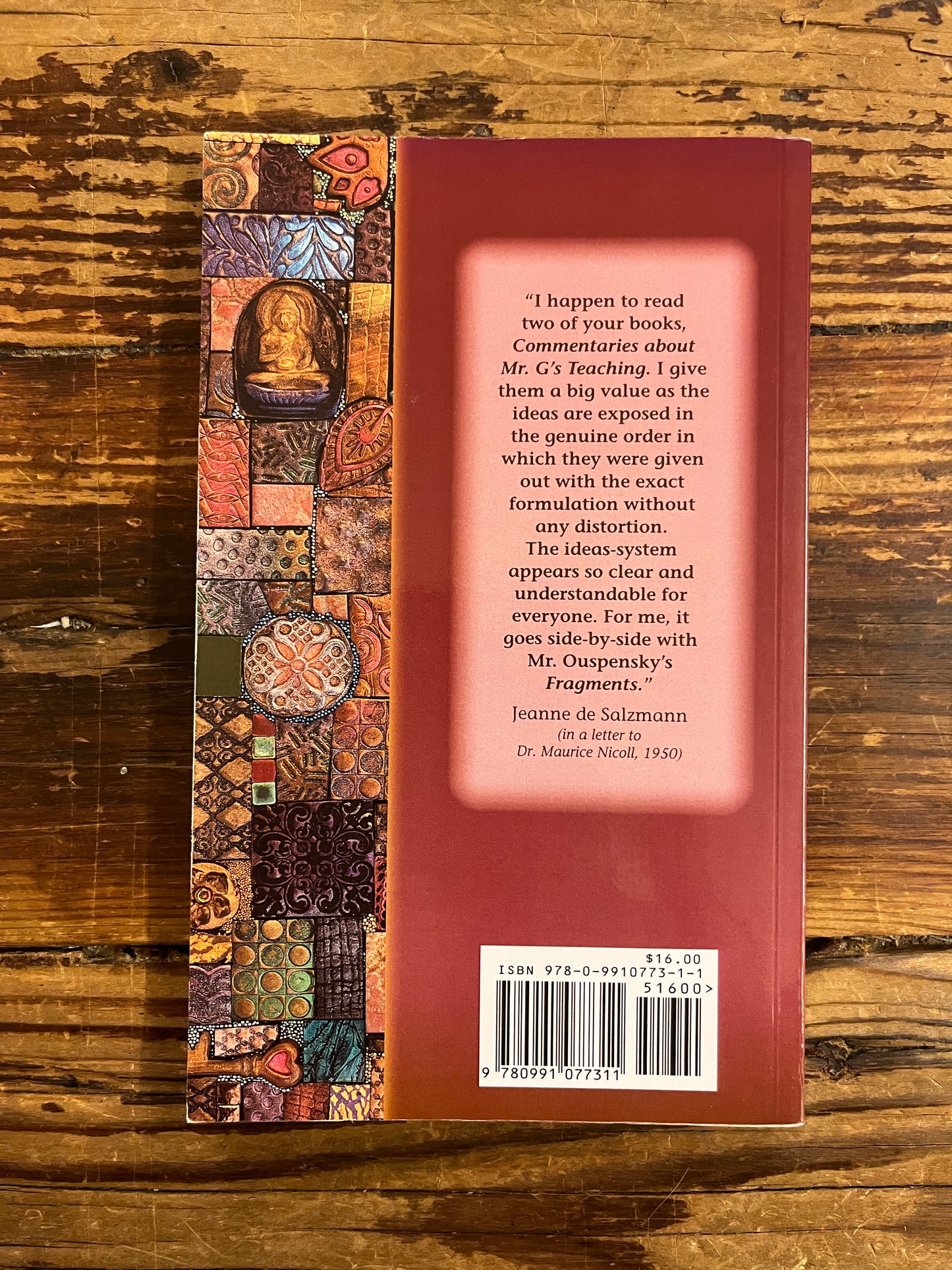 Back cover of a book with the title 'Gems of Wisdom' by Maurice Nicoll on a wooden surface