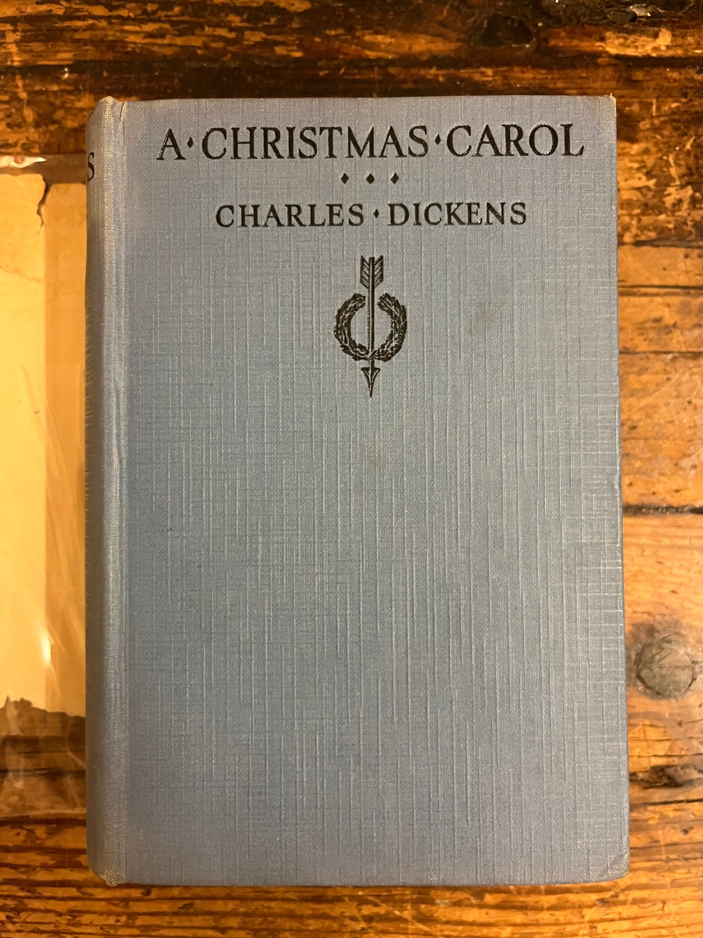 cover of the book "a christmas carol'without its jacket on a wooden ackground